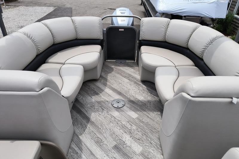 2017 Manitou 25 Oasis SE pontoon boat with plush seating and wood-style flooring.
