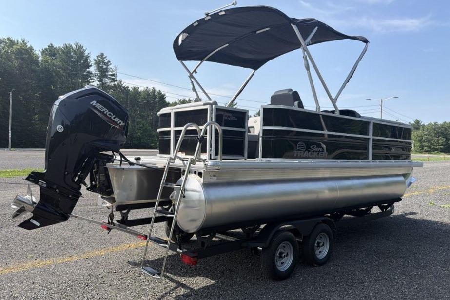2026 Sun Tracker Party Barge 20 DLX pontoon boat with canopy and outboard motor.