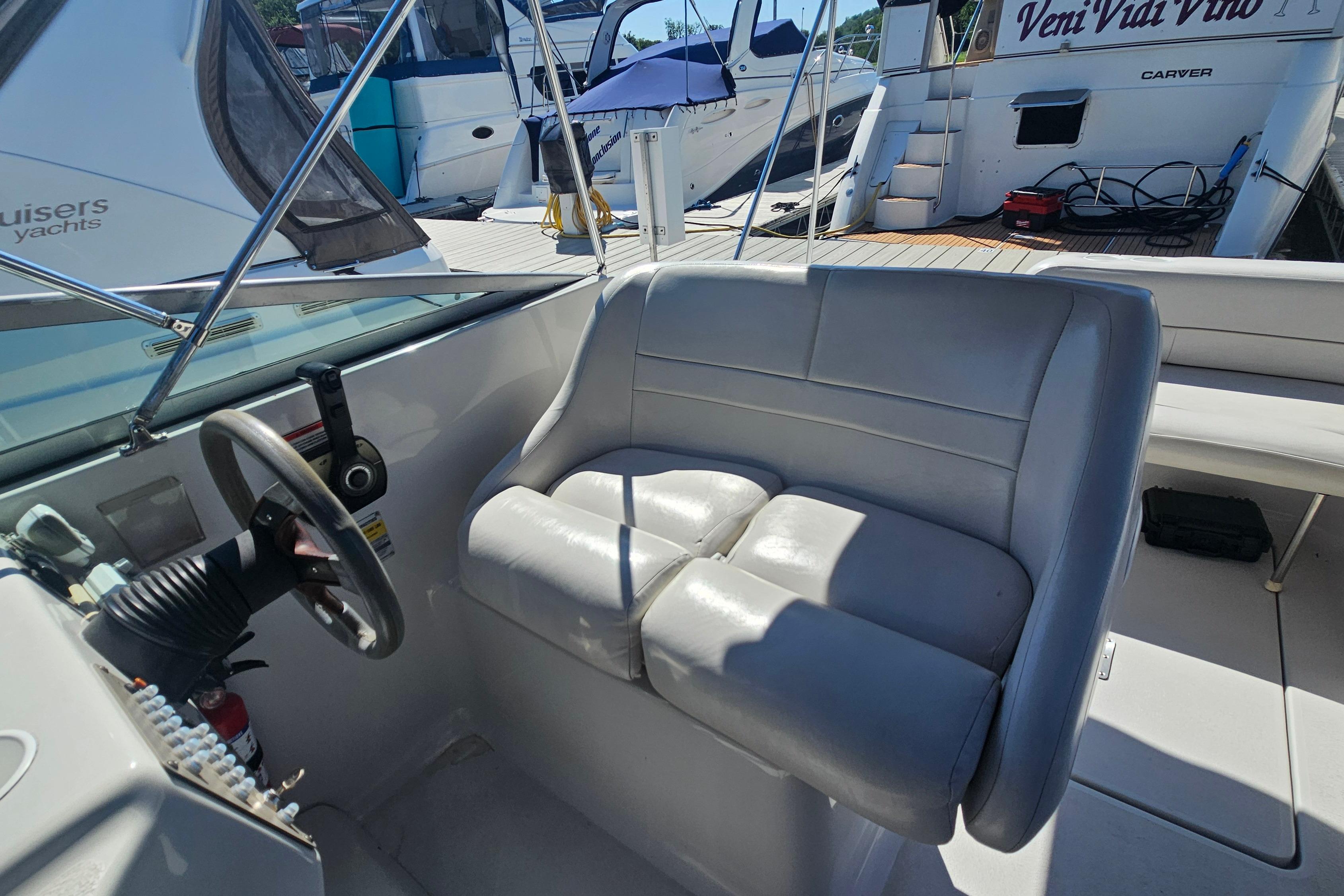 2000 Crownline 242 CR boat interior with steering wheel and cushioned seating.