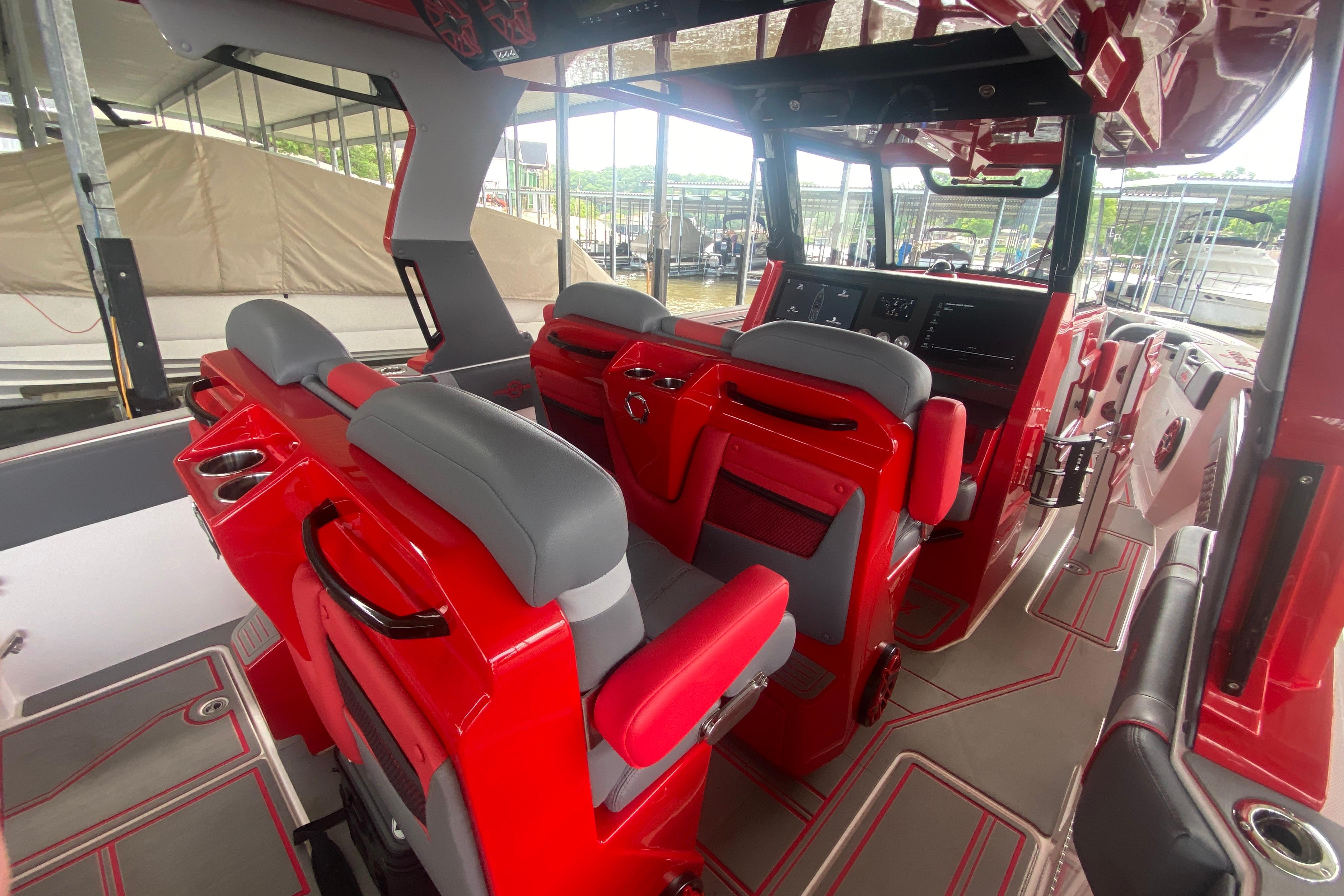 Interior of 2025 Fountain 38 SCX boat with red and gray seating and modern dashboard.