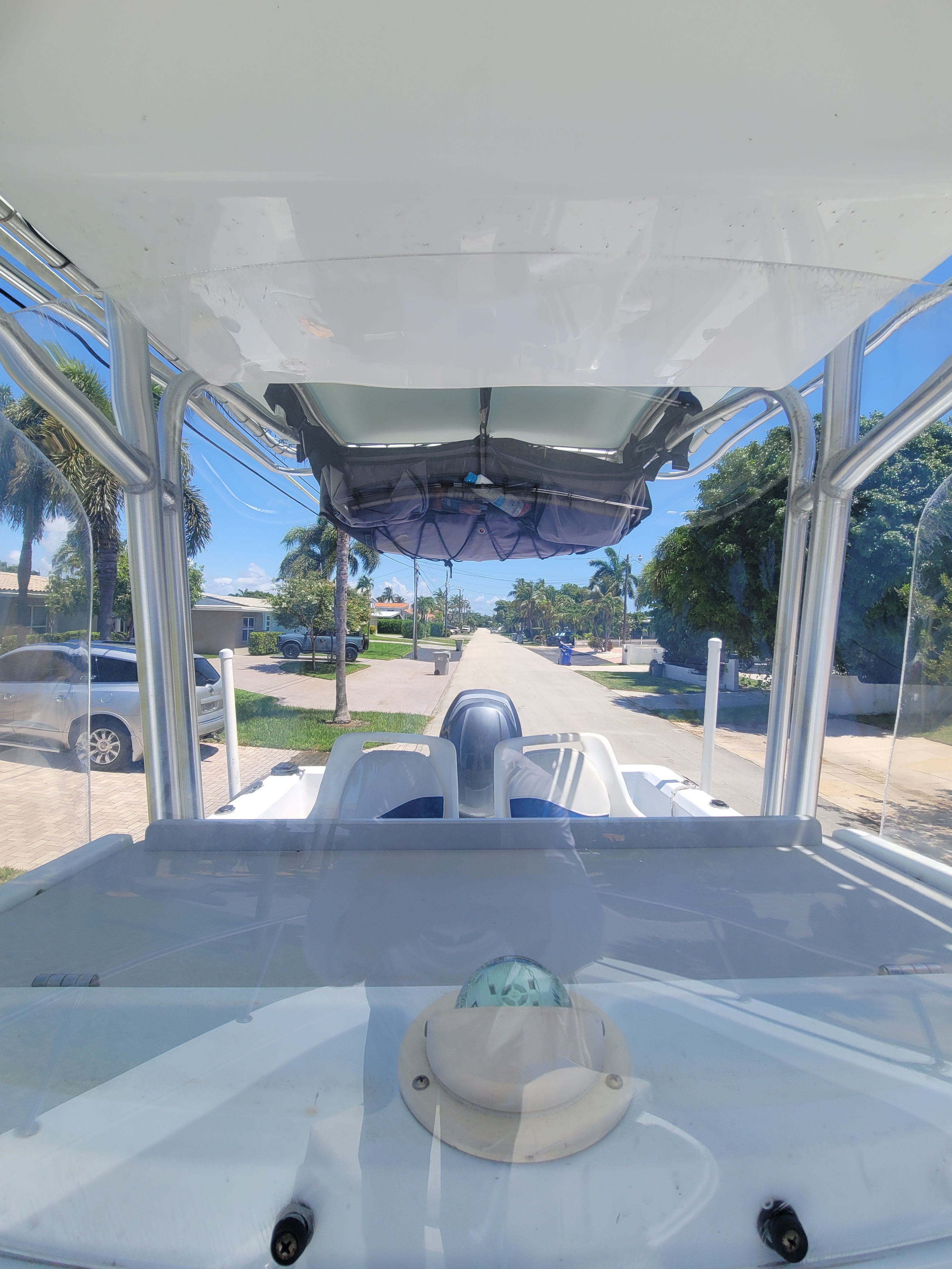 View from the boat overlooking a quiet street with palm trees and houses.