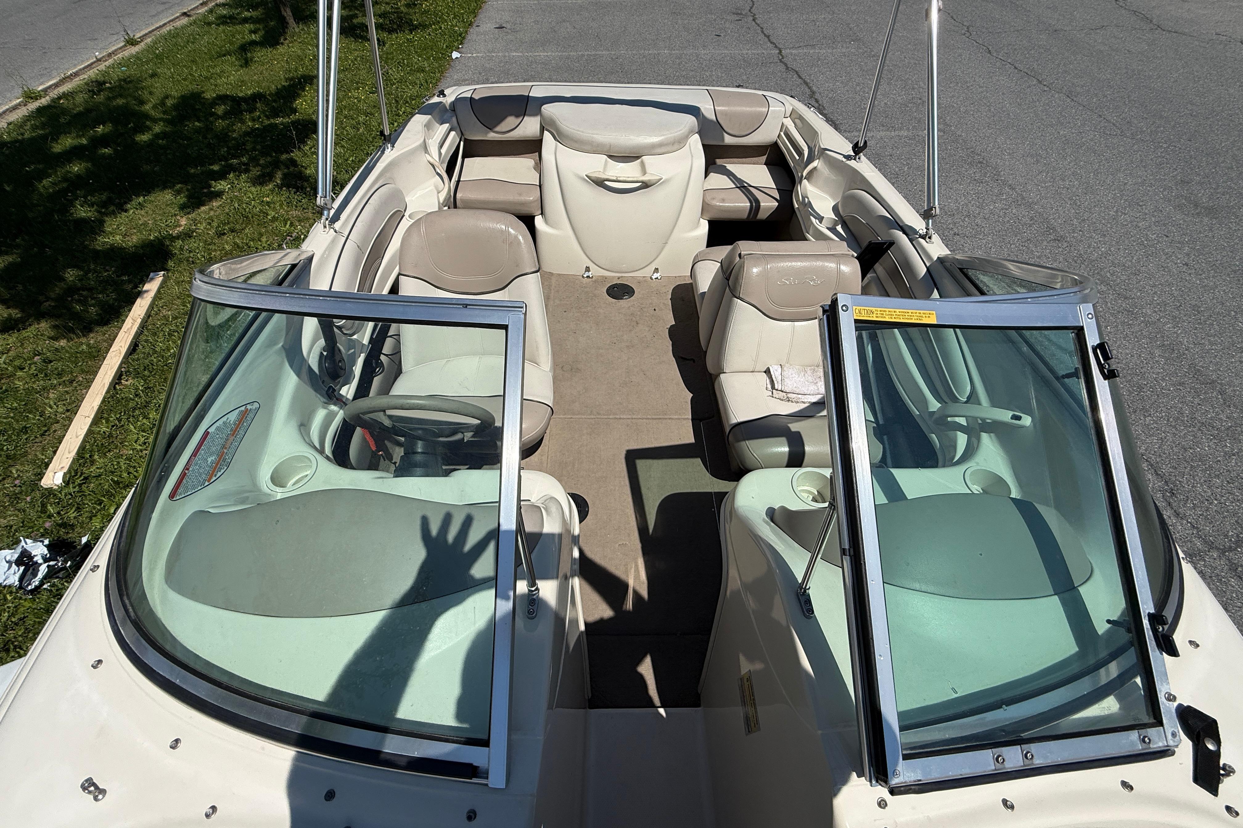 2003 Sea Ray 182 Bow Rider boat interior with beige seating and open windshield.