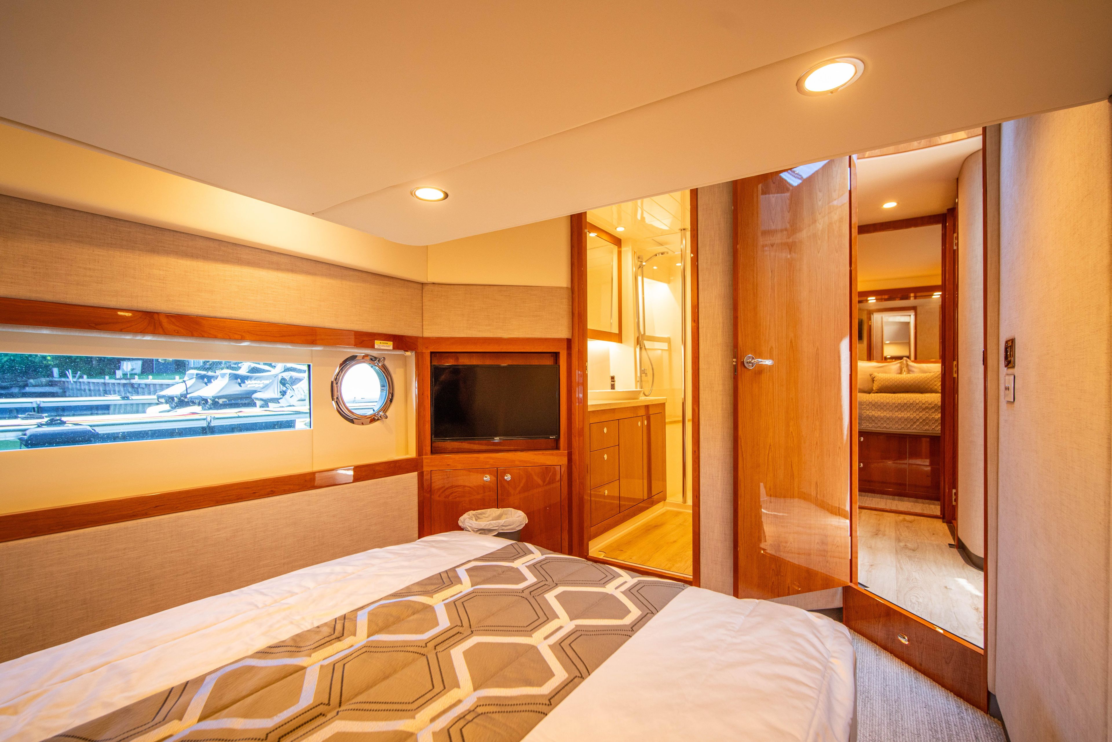 Luxurious interior of 2020 Riviera 525 SUV yacht bedroom with modern amenities.