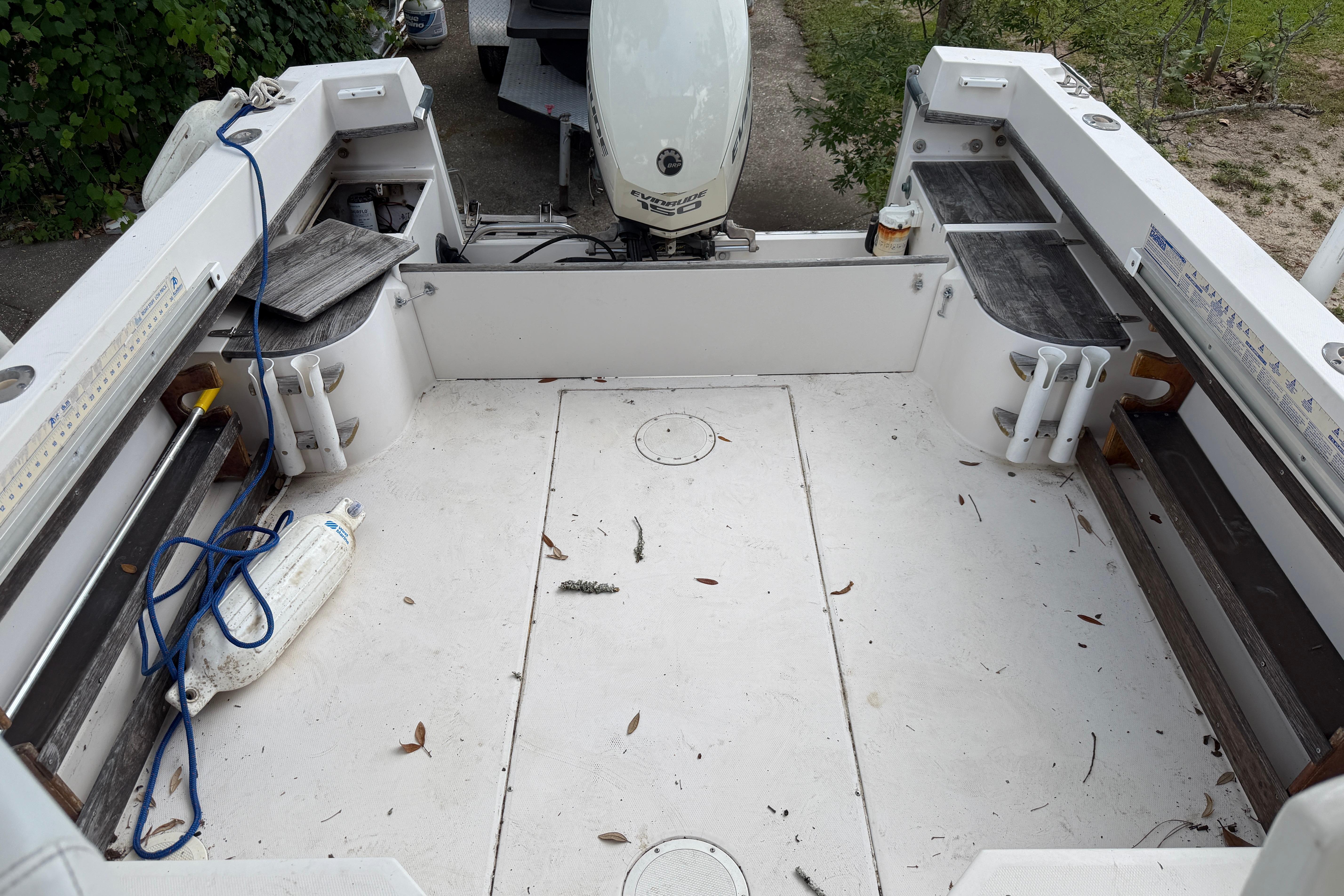 1987 Grady-White Seafarer 226 boat deck with motor, fishing rod holders, and storage compartments.