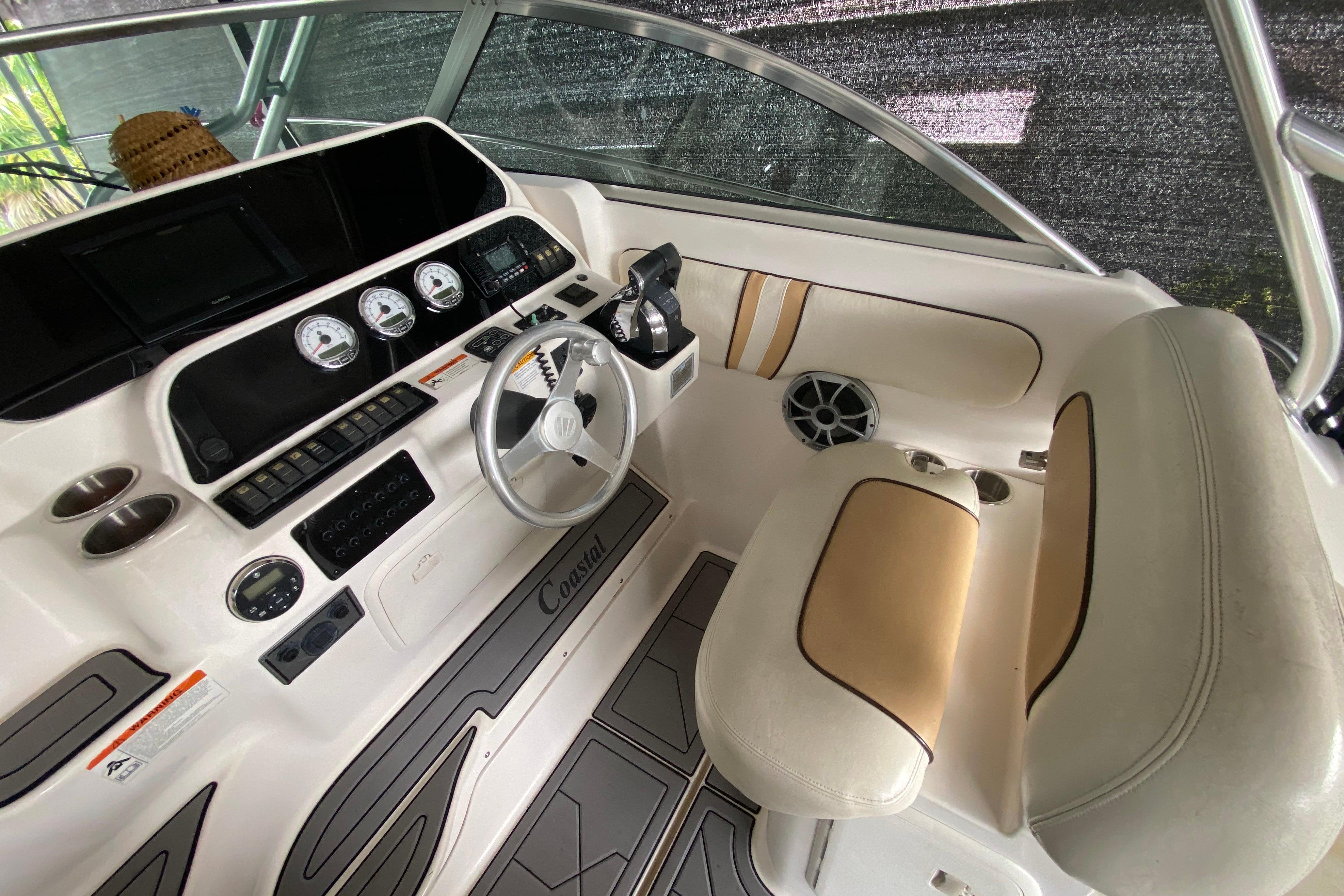 2005 Wellcraft 290 Coastal boat cockpit with steering wheel and instrument panel.
