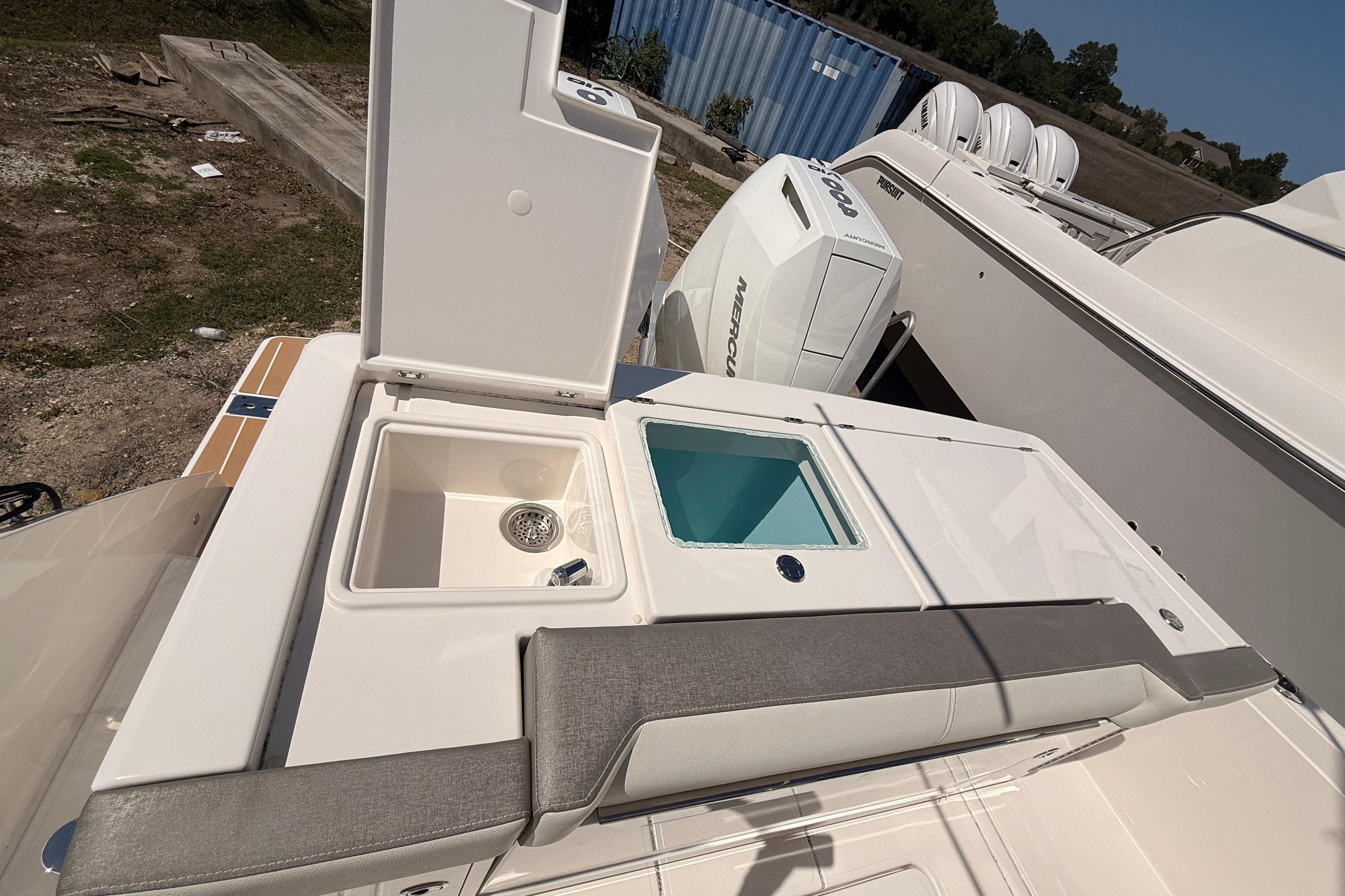 2024 Tiara Yachts 34 LS boat deck with storage compartments and Mercury outboard engine.