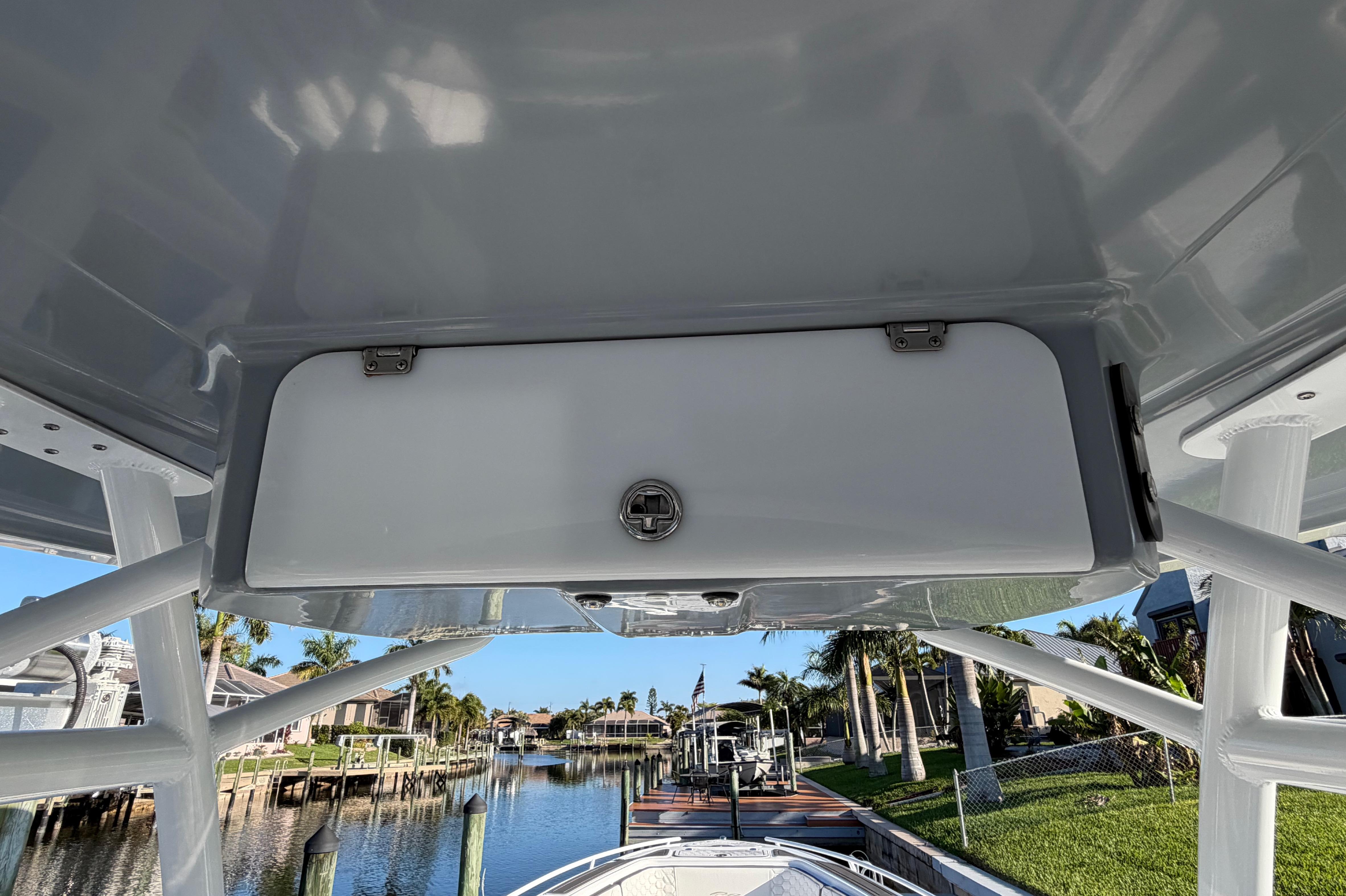 2022 Glasstream 328 Pro-XS boat interior with storage compartment, docked near waterfront homes.