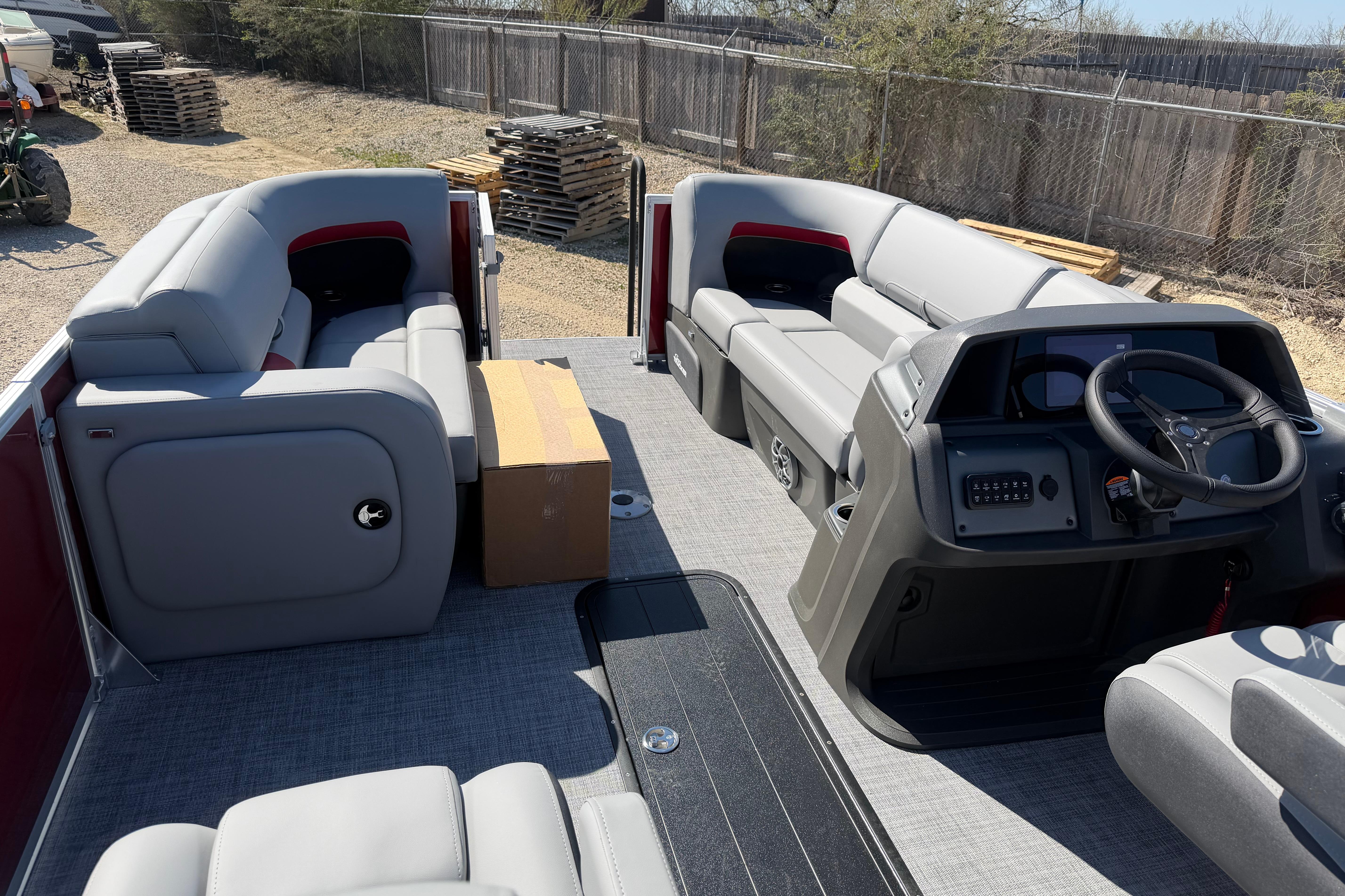 2026 Sun Tracker Party Barge 22 RF XP3 interior with gray seating and steering console.