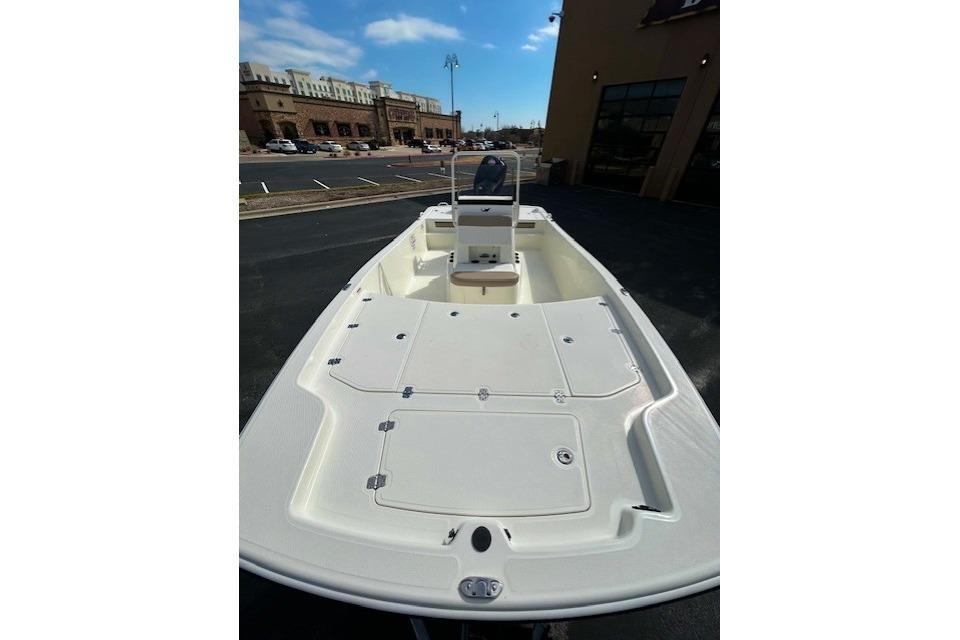 2026 Mako Pro Skiff 19 CC boat, white deck, parked outdoors under blue sky.