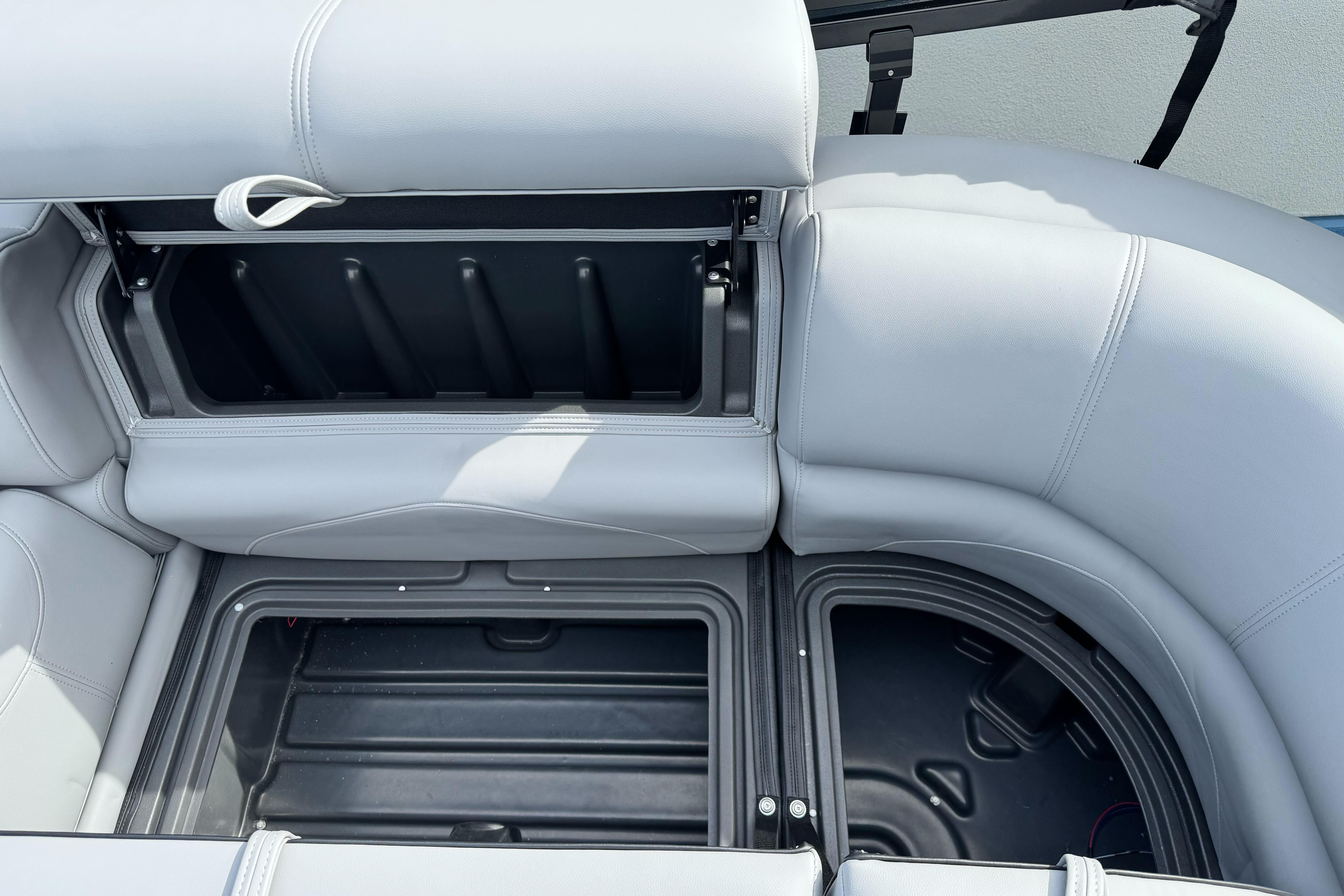Open storage compartment in 2026 Regency 250 DL boat with gray seating.