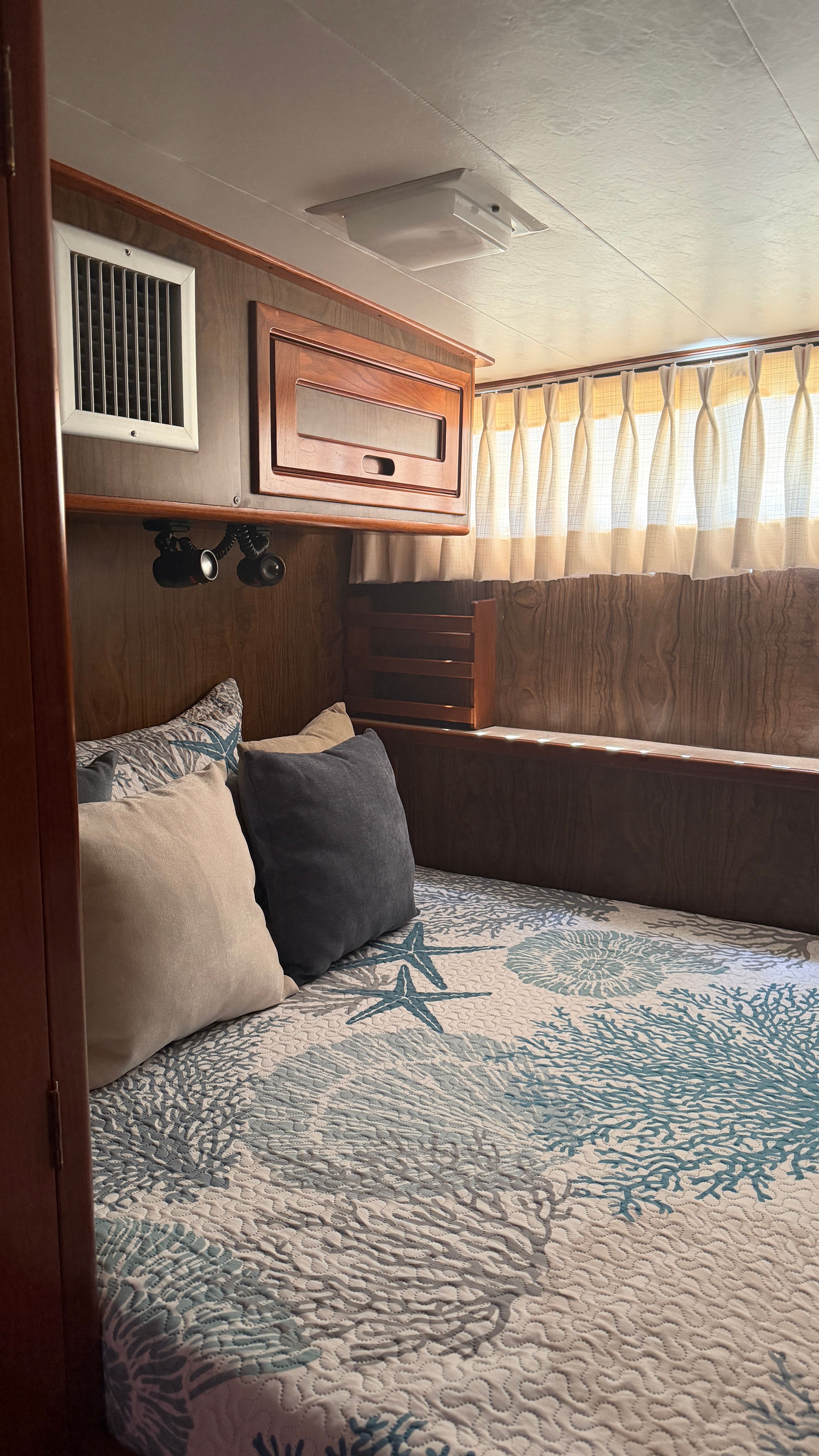 Interior of a 1966 Drake Yachtfisher with cozy bed and pillows.
