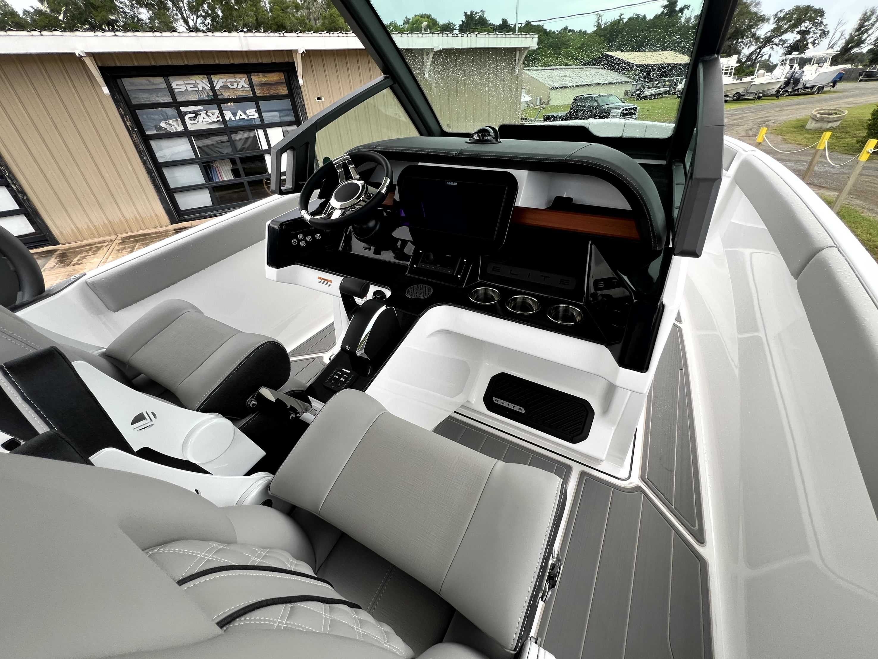 The image shows the cockpit of a 2026 Monterey Elite 25 boat with modern seating and instruments.
