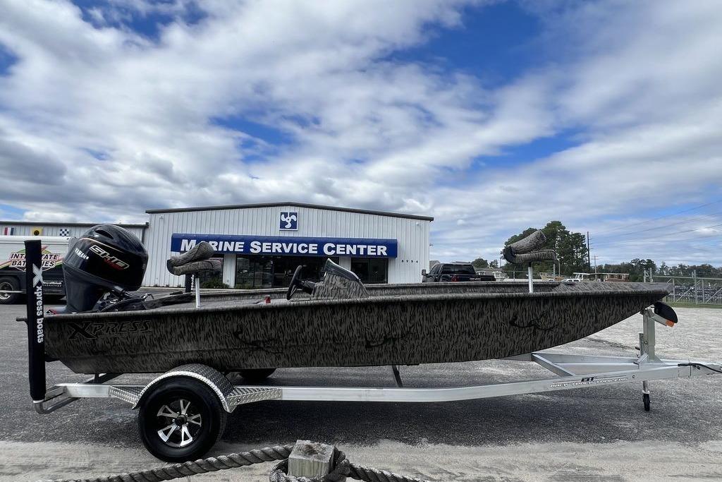 2026 Xpress XP200 boat on trailer at Marine Service Center, under cloudy sky.