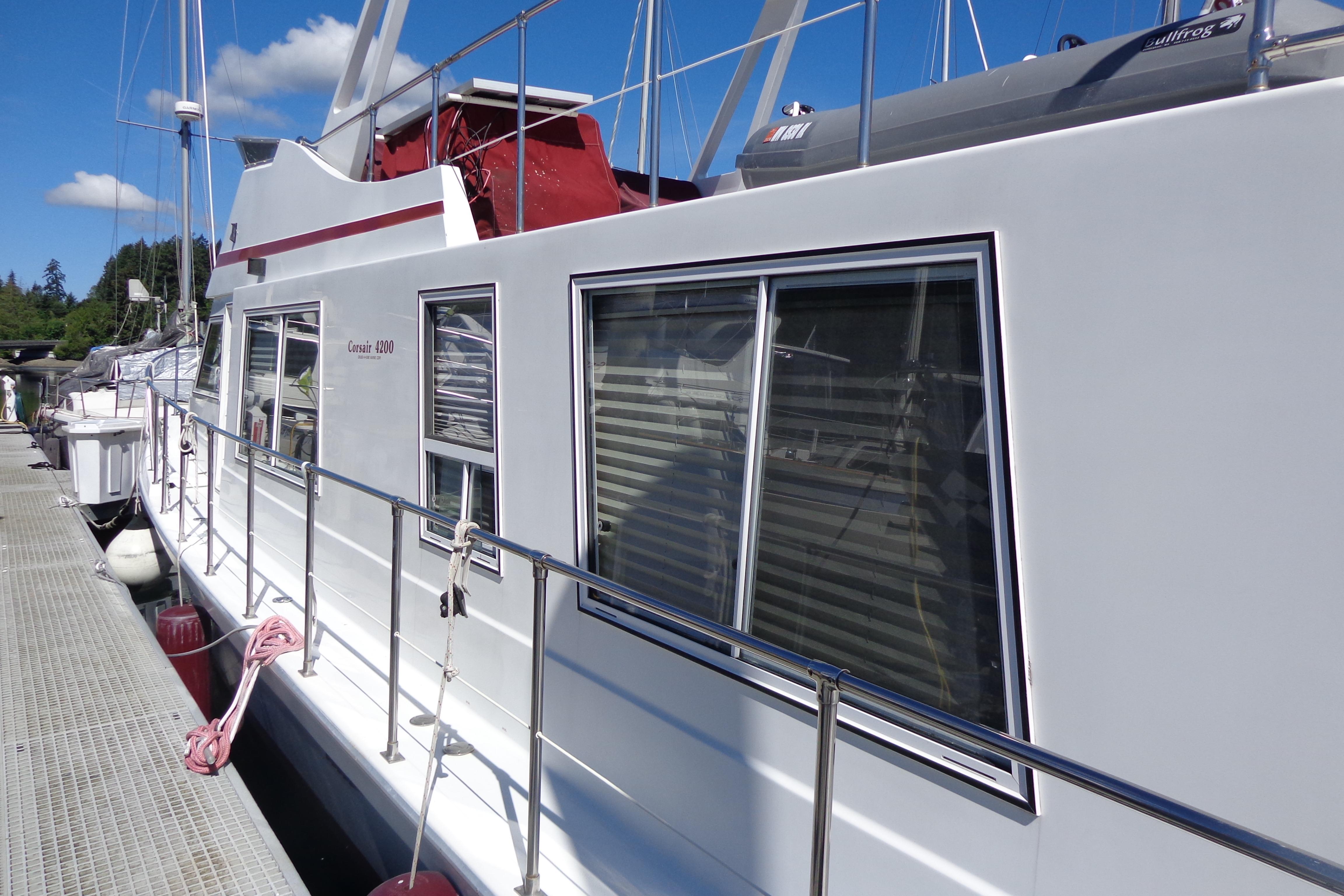 1992 Cruise-A-Home Corsair 4200 docked, featuring sleek white exterior and large windows.