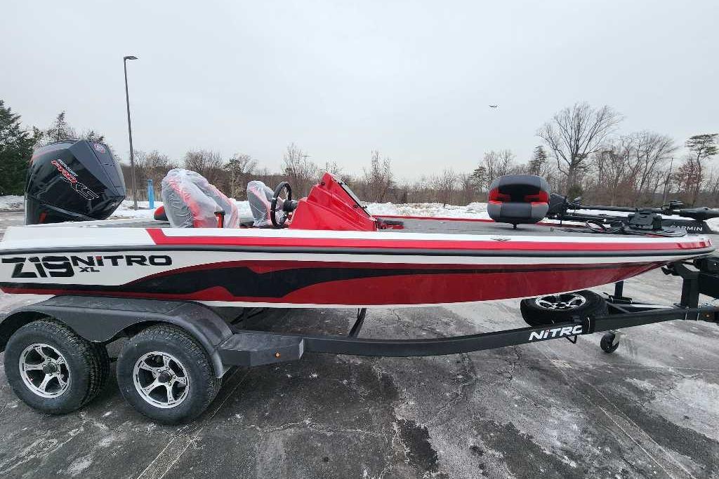 2026 Nitro Z19 XL Pro boat on trailer, red and white design, parked outdoors.