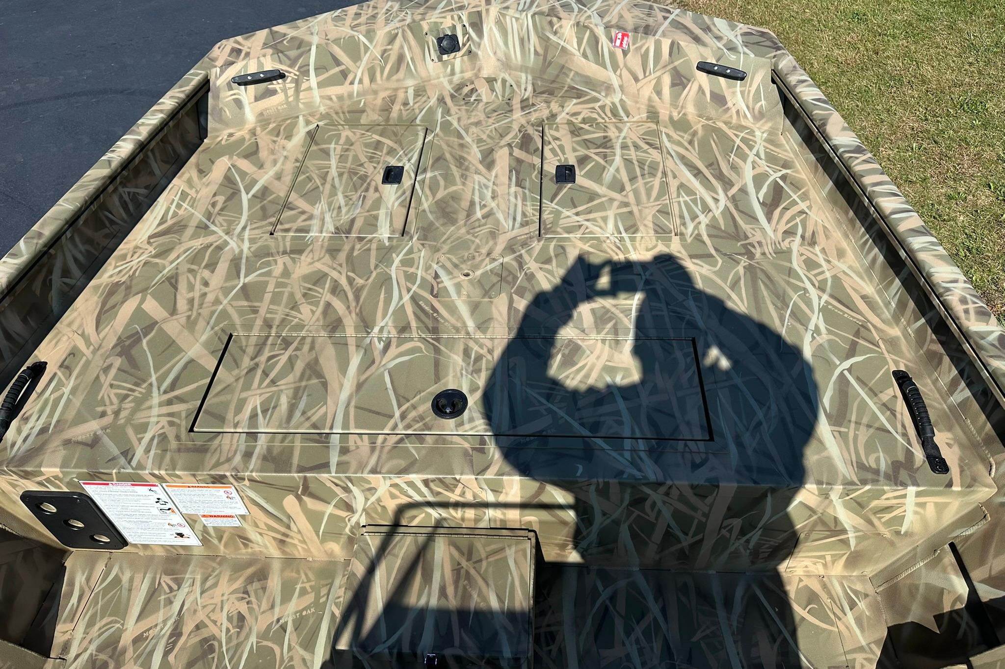 Camouflage-patterned deck of 2026 Lowe Roughneck 2070CC boat with shadow.