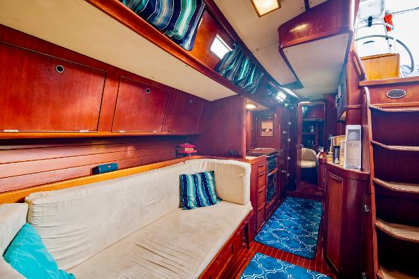 Interior of 1989 Concordia 52 yacht with wooden cabinetry and cozy seating area.