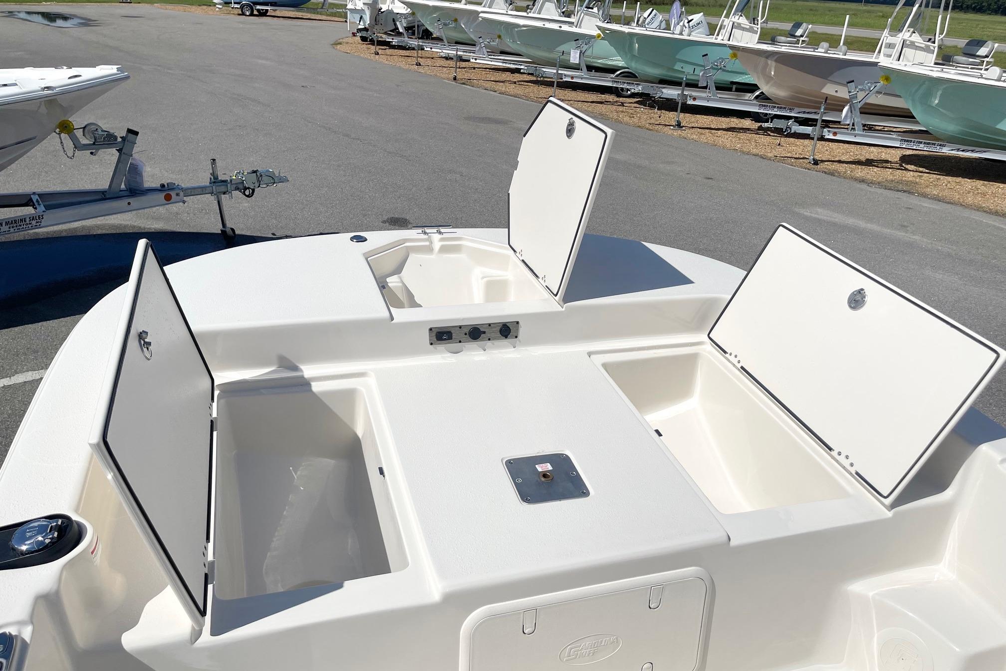 2026 Carolina Skiff 19 LS boat with open storage compartments in a marina setting.