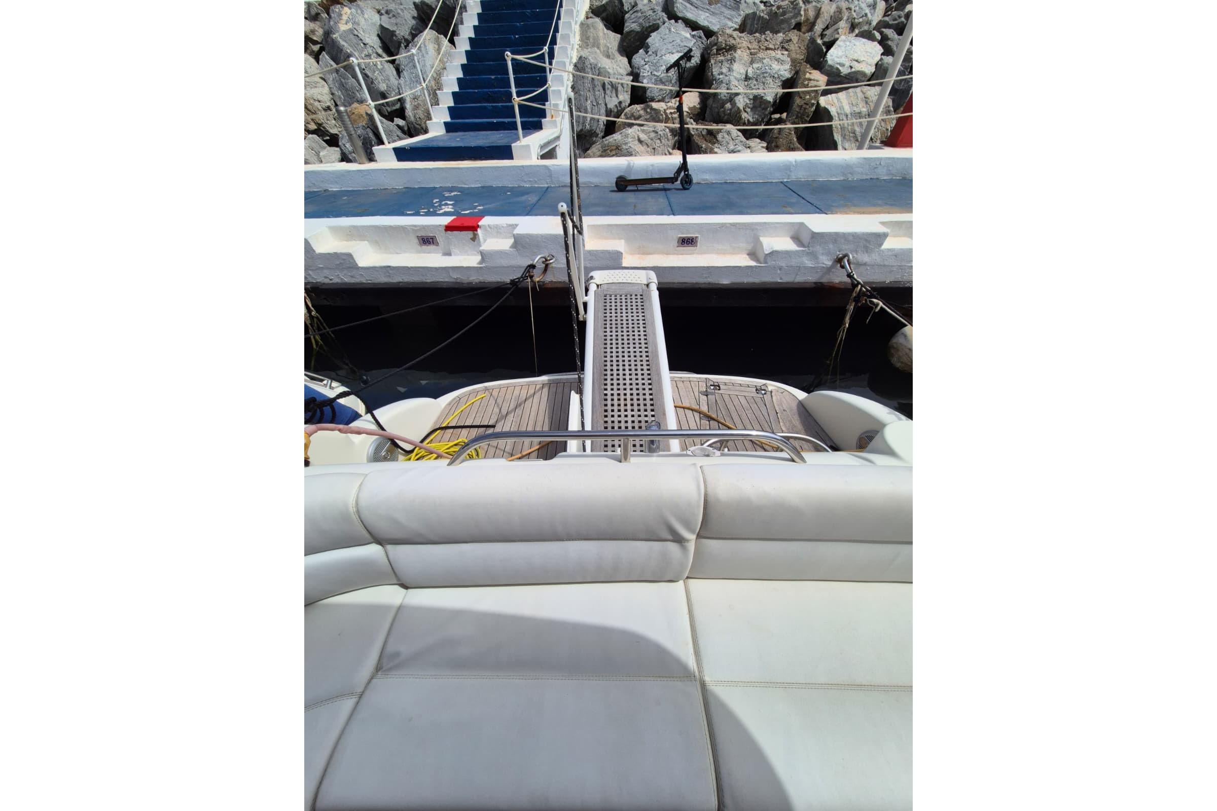 Luxury yacht Atlantis 345sc (2008) docked at marina with cushioned seating.