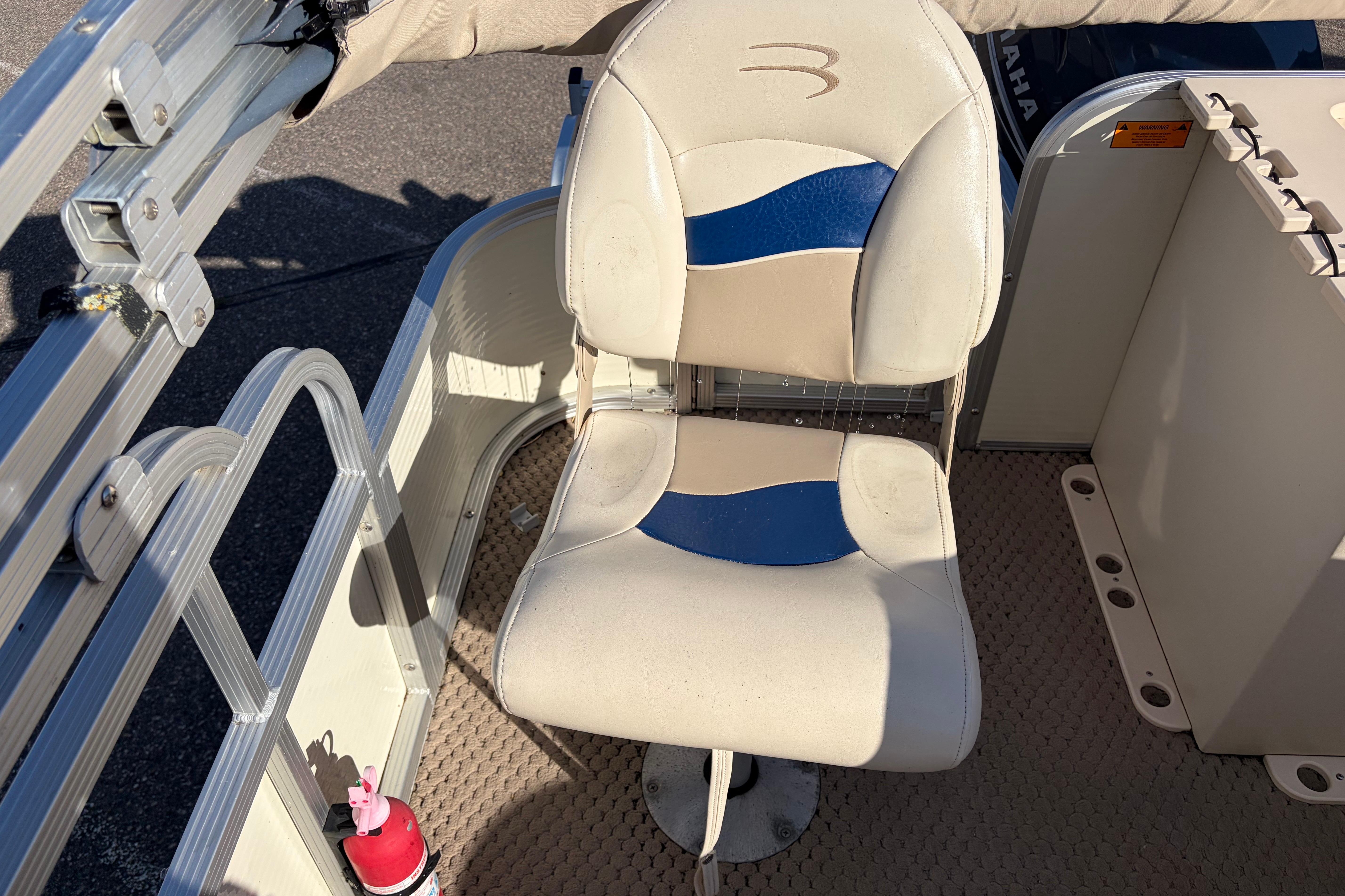 Captain's chair on a 2003 Bennington 2250RSi pontoon boat, featuring blue and beige upholstery.