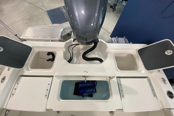 2024 Key West 250 Bay Reef boat stern with storage compartments and outboard motor.
