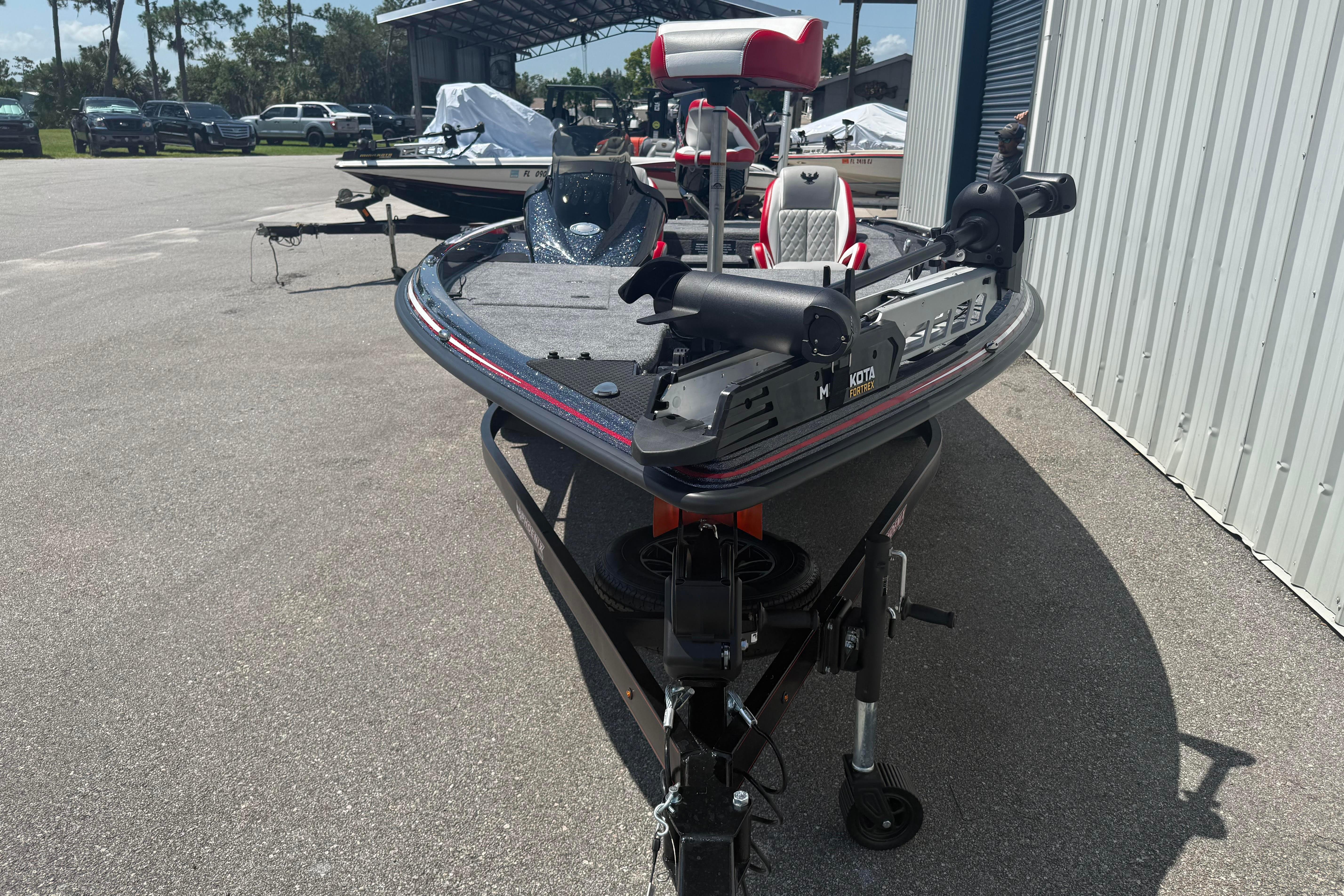 2027 Phoenix 819 ZXL boat on trailer, parked outdoors near a metal building.