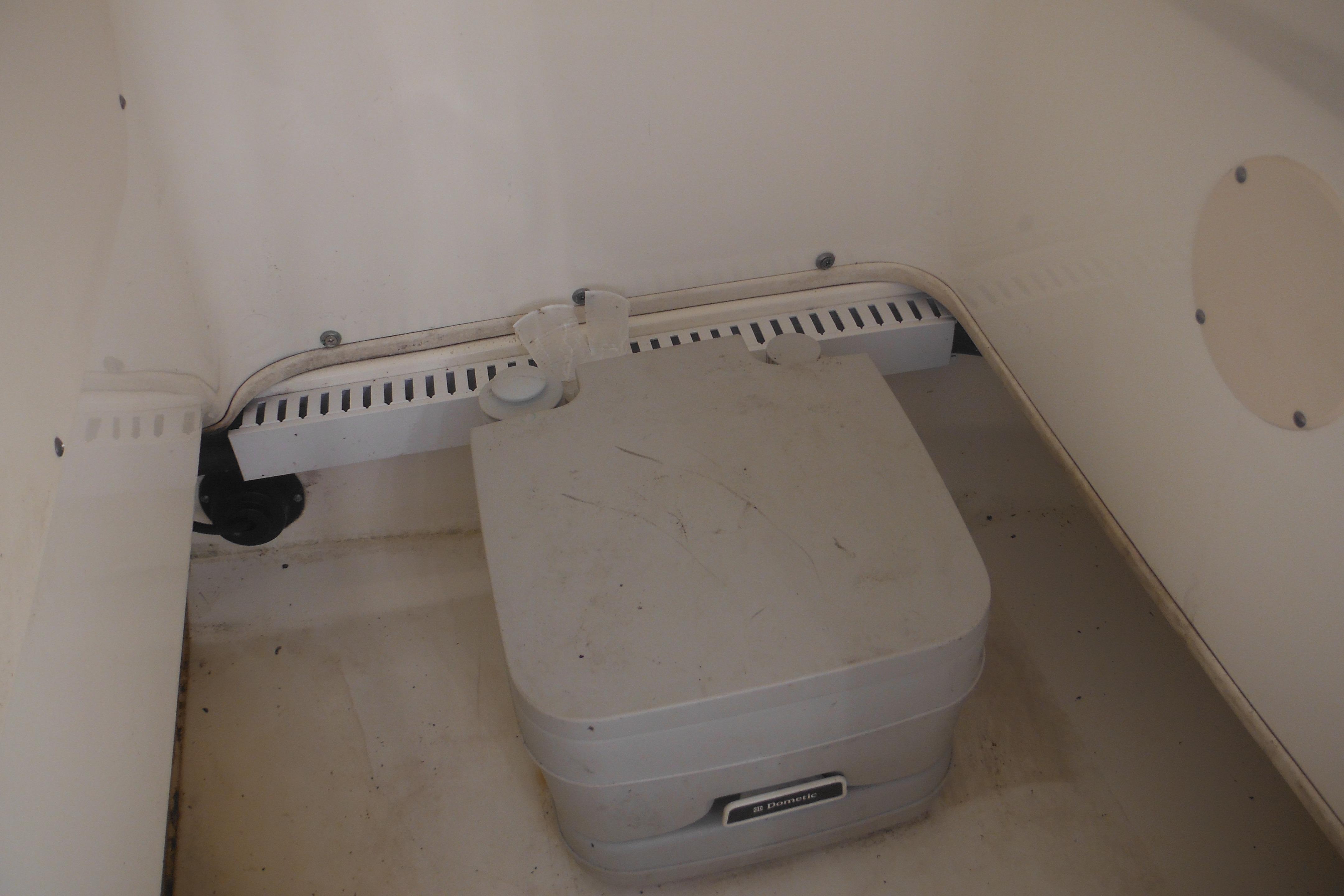 2009 Boston Whaler 200 Dauntless interior storage compartment with portable toilet.