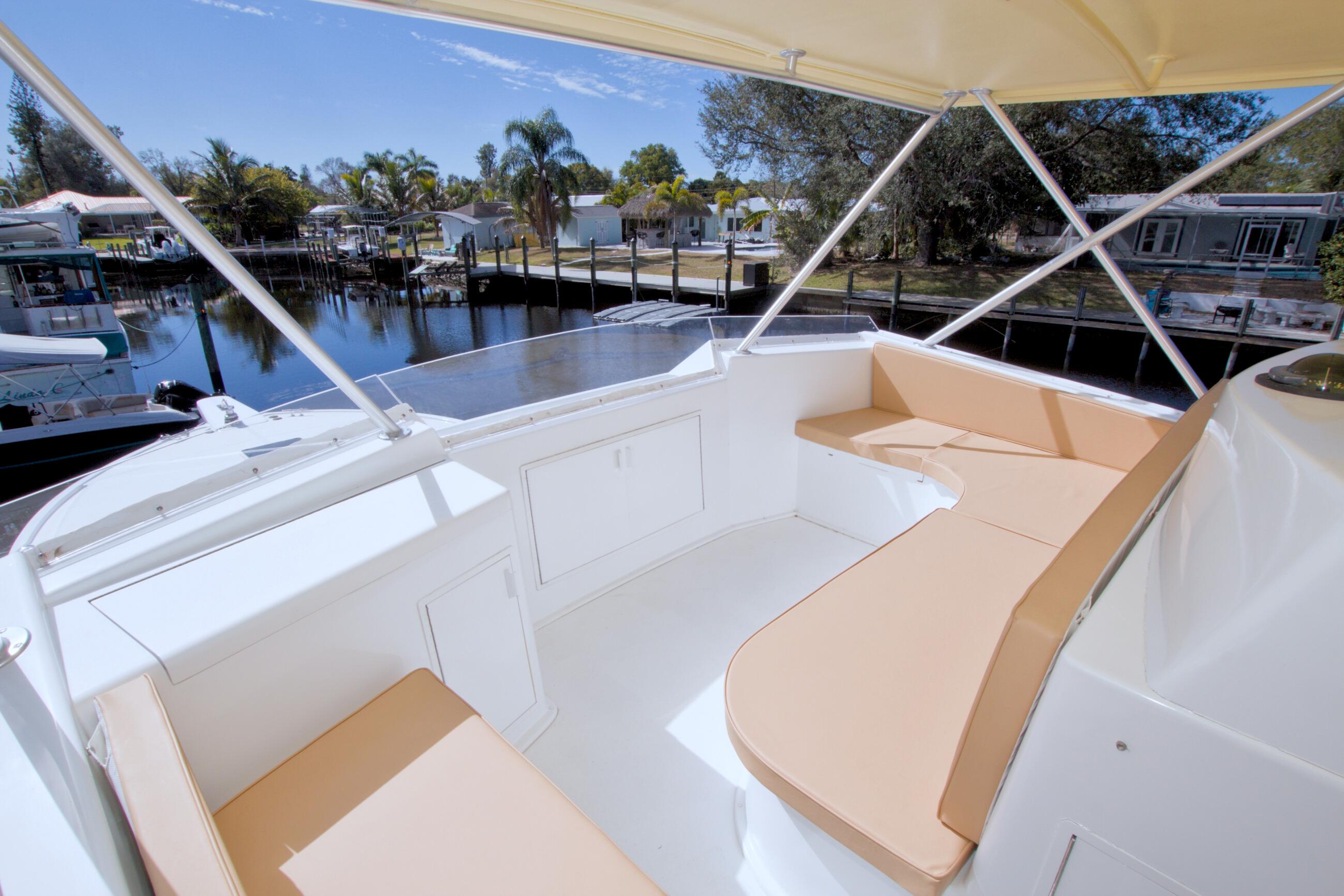 1990 Viking 53 Convertible yacht with spacious outdoor seating area, docked by a serene waterfront.