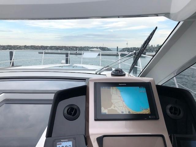 Galeon 485 yacht cockpit with navigation system, overlooking calm waters, 2018 model.