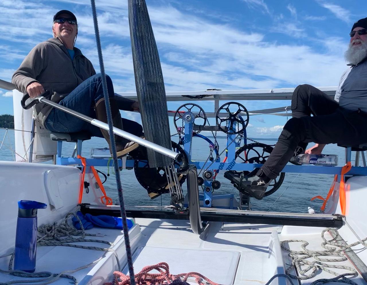 Two people sailing on a Seascape 27 boat, enjoying a sunny day.