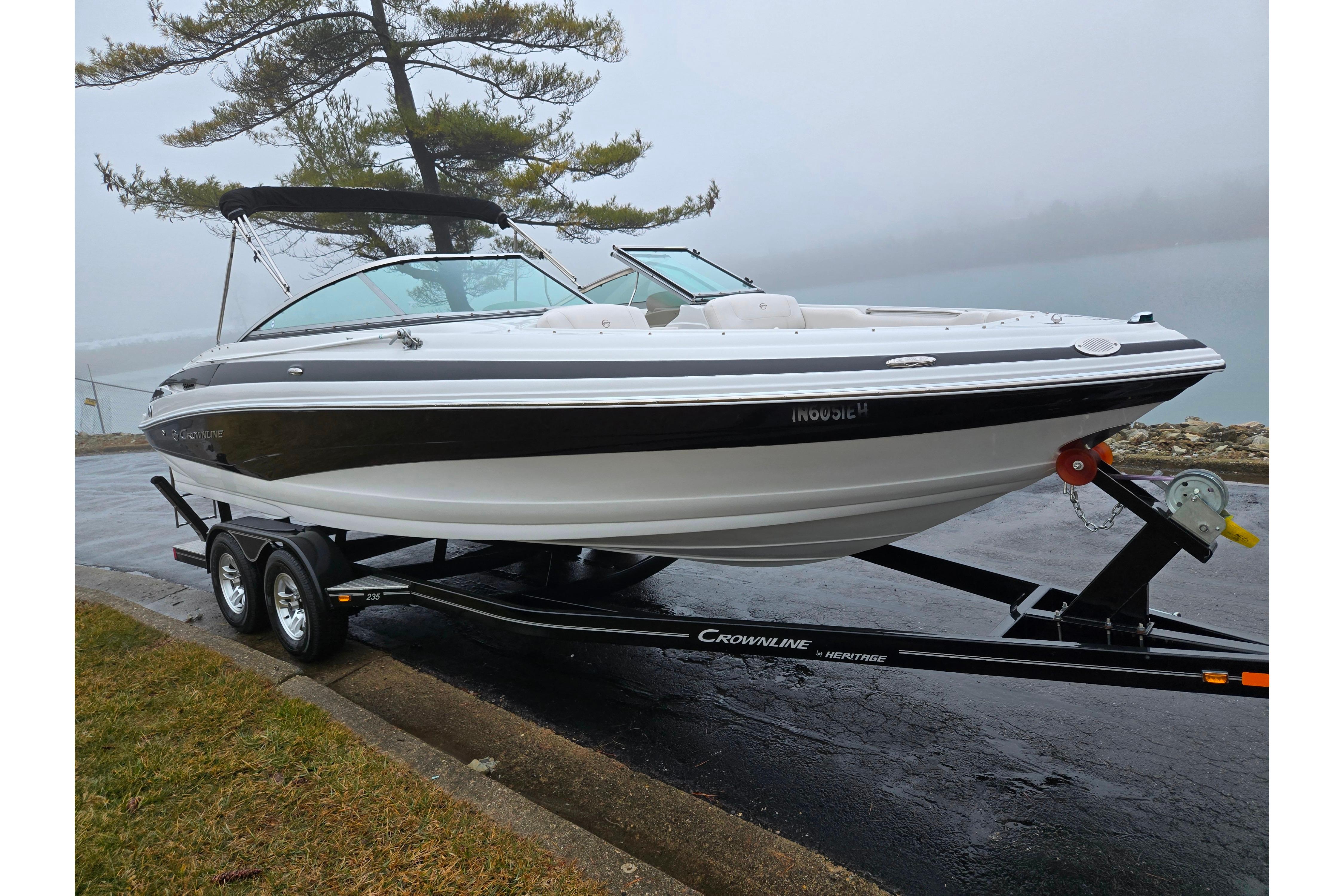 2012 Crownline 235 SS boat on trailer, parked near a foggy lake.
