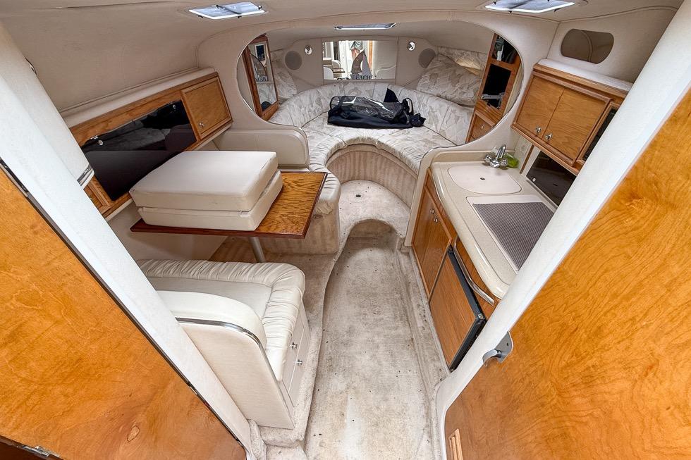 Interior of a 1999 Sea Ray 290 Sundancer boat with seating and kitchenette.