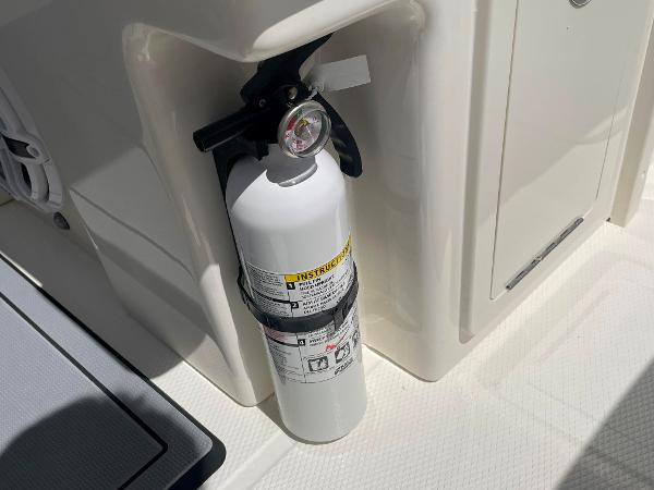 Fire extinguisher on 2023 Robalo R270 boat, securely mounted for safety.