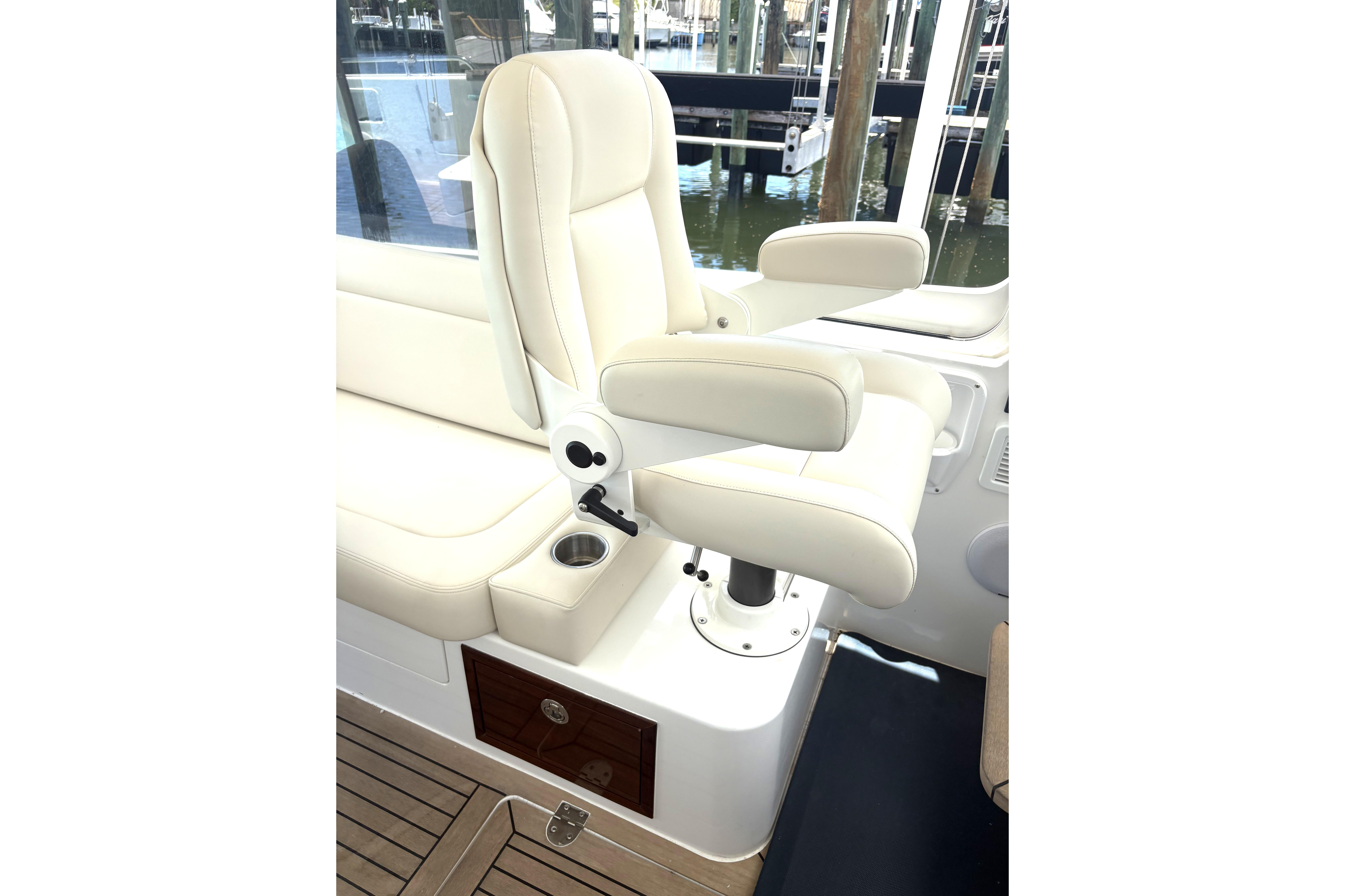 Luxury seating on 2024 MJM 35z boat, featuring cream upholstery and armrests.