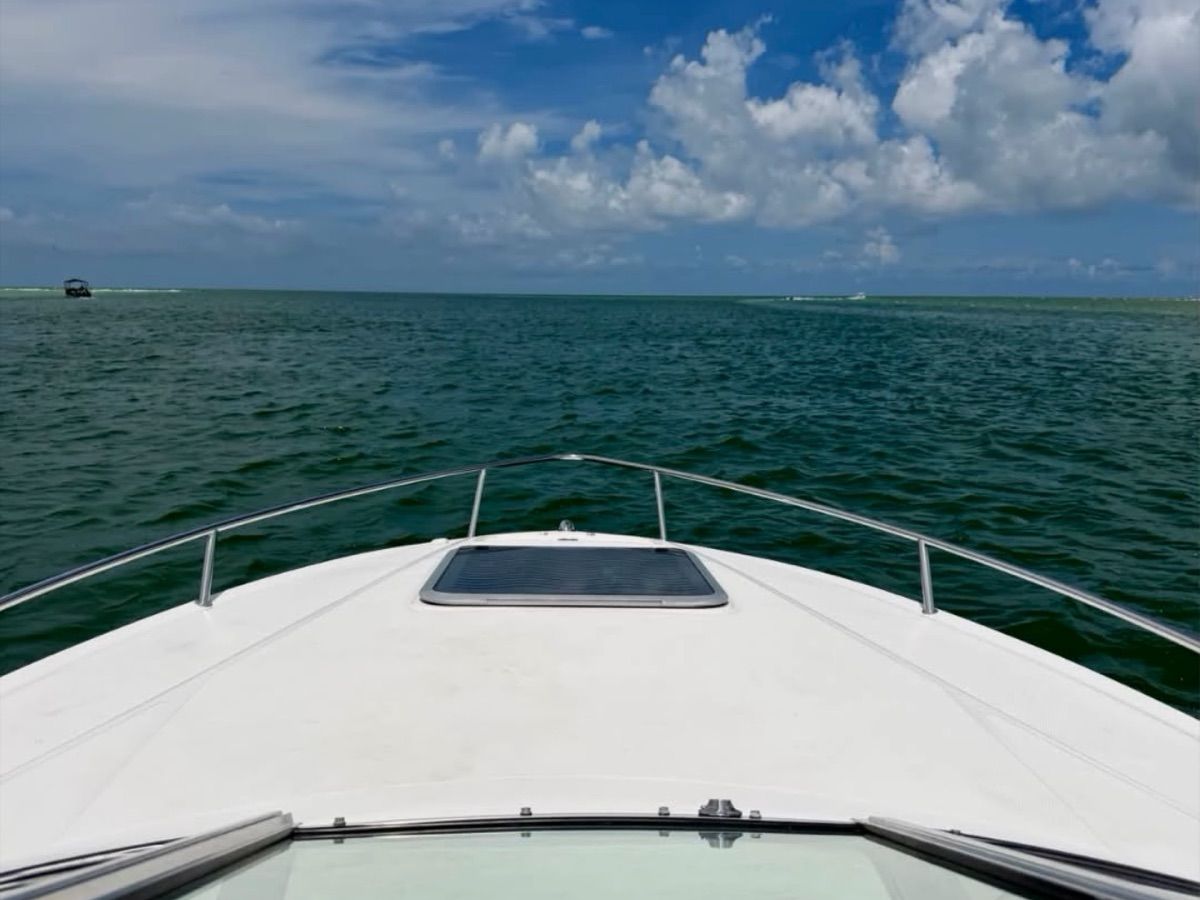 View from the bow of a boat looking out to open sea under a blue sky.