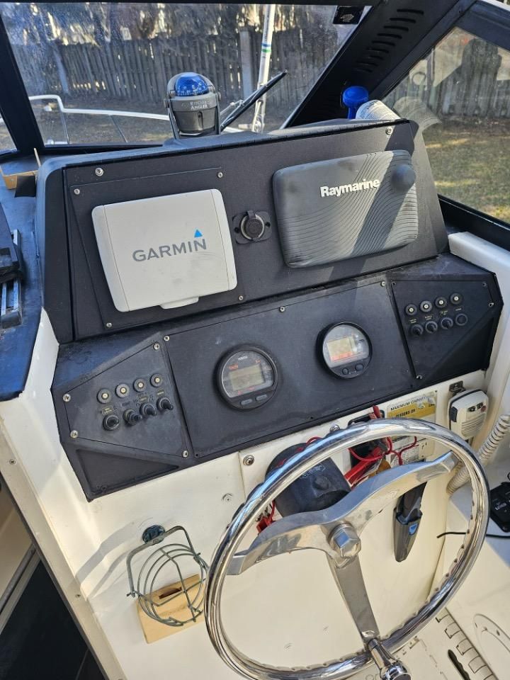 Dashboard of a 1991 Pro-Line Cuddy Cabin boat with Garmin and Raymarine devices.