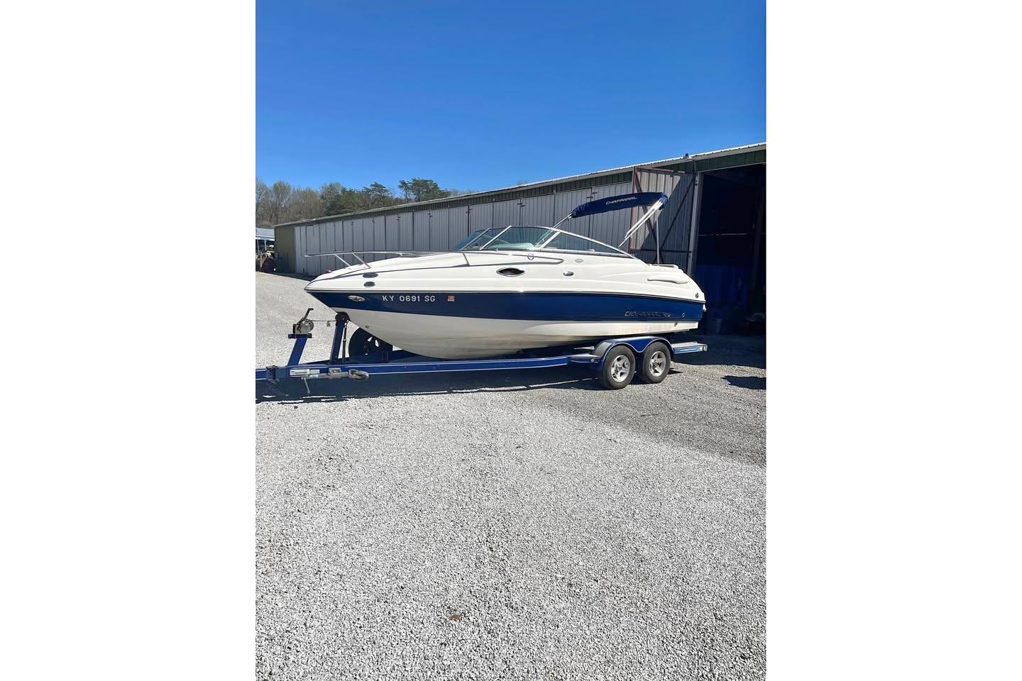 2007 Chaparral 215 SSi boat on trailer, parked outdoors near a building.