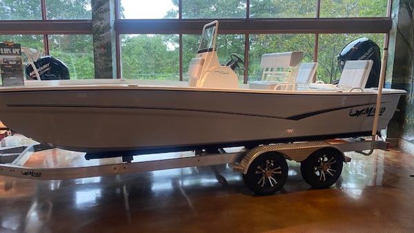 2023 Mako Pro Skiff 19 CC boat on a trailer in a showroom.