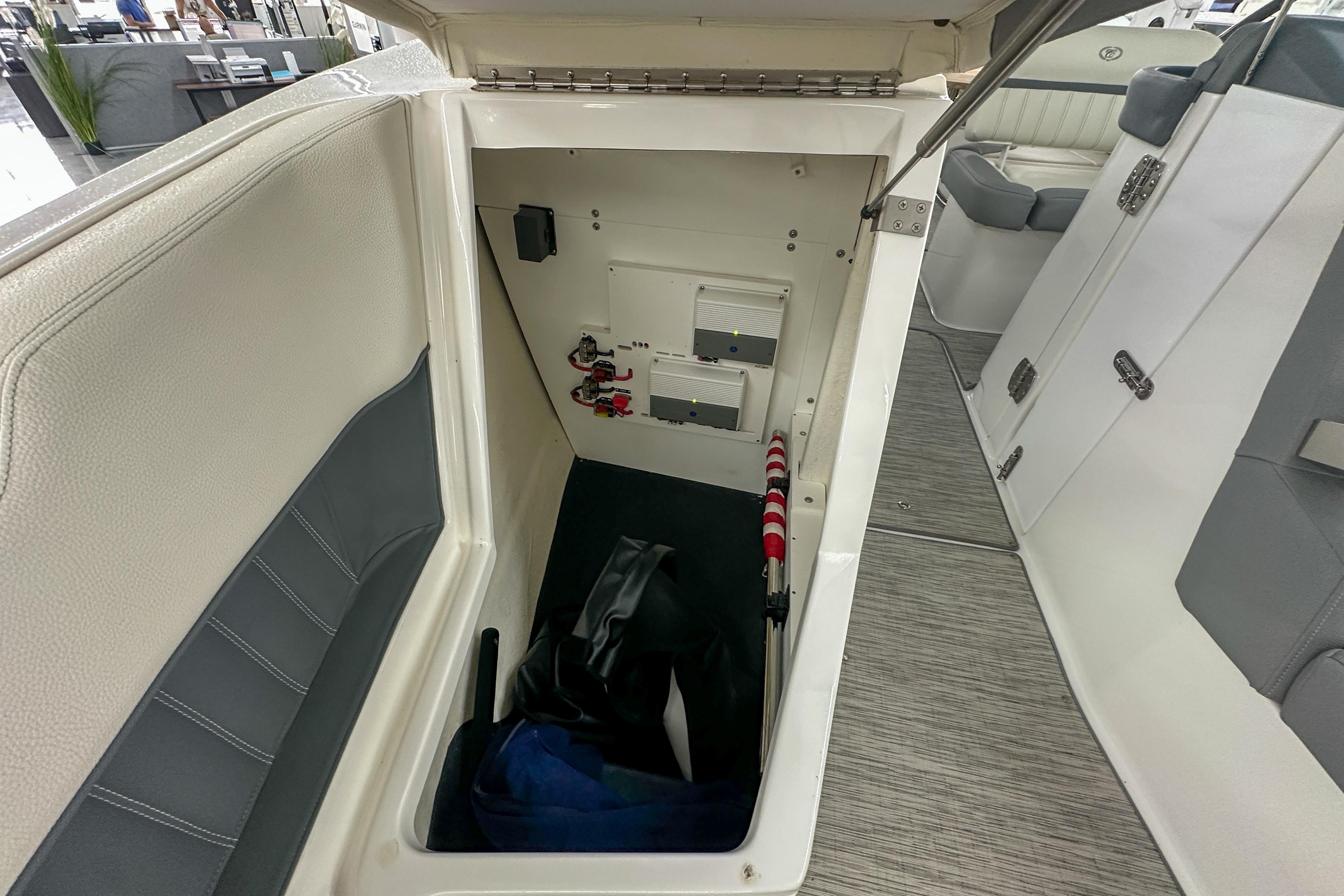 2022 Cobalt 25SC boat storage compartment with electrical components and safety equipment.