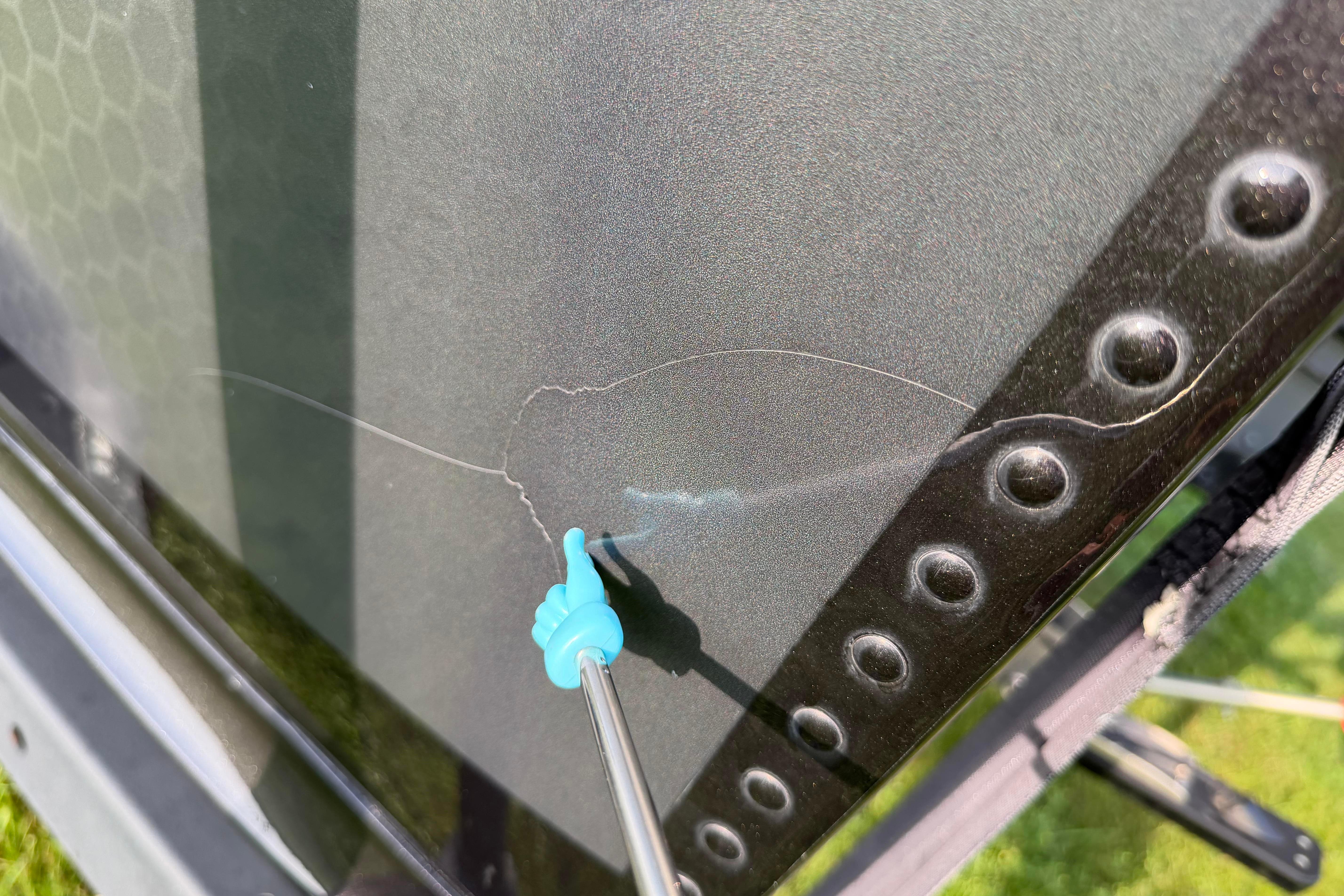 Cracked windshield on 2019 Alumacraft Trophy 205 boat, highlighted with a blue pointer.