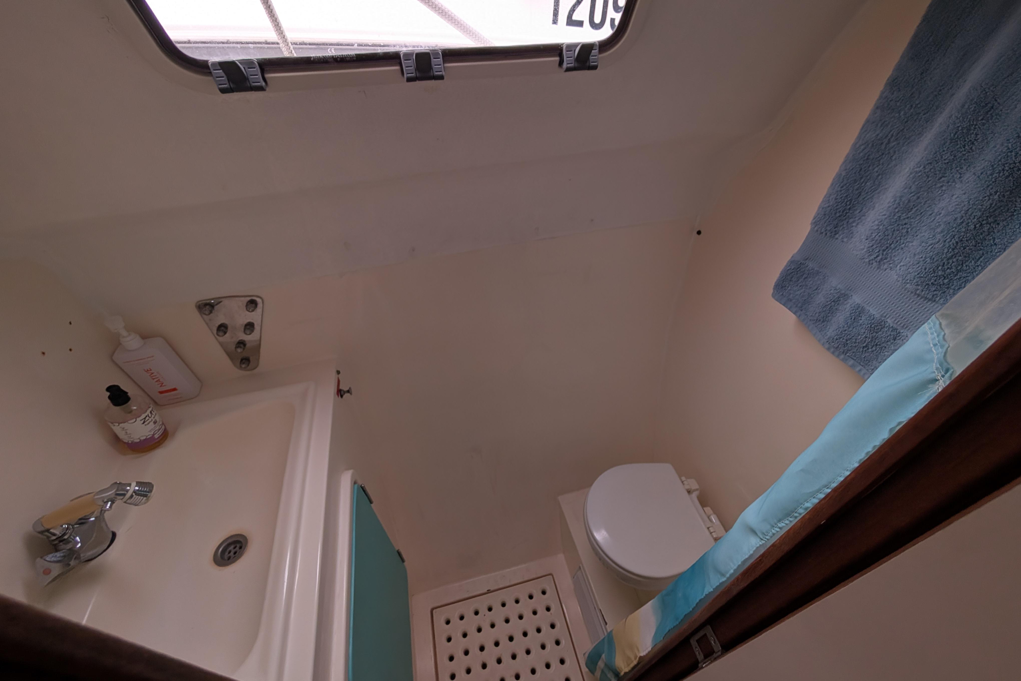 Bathroom interior of 1999 Island Spirit 37 yacht, featuring sink, toilet, and towel.