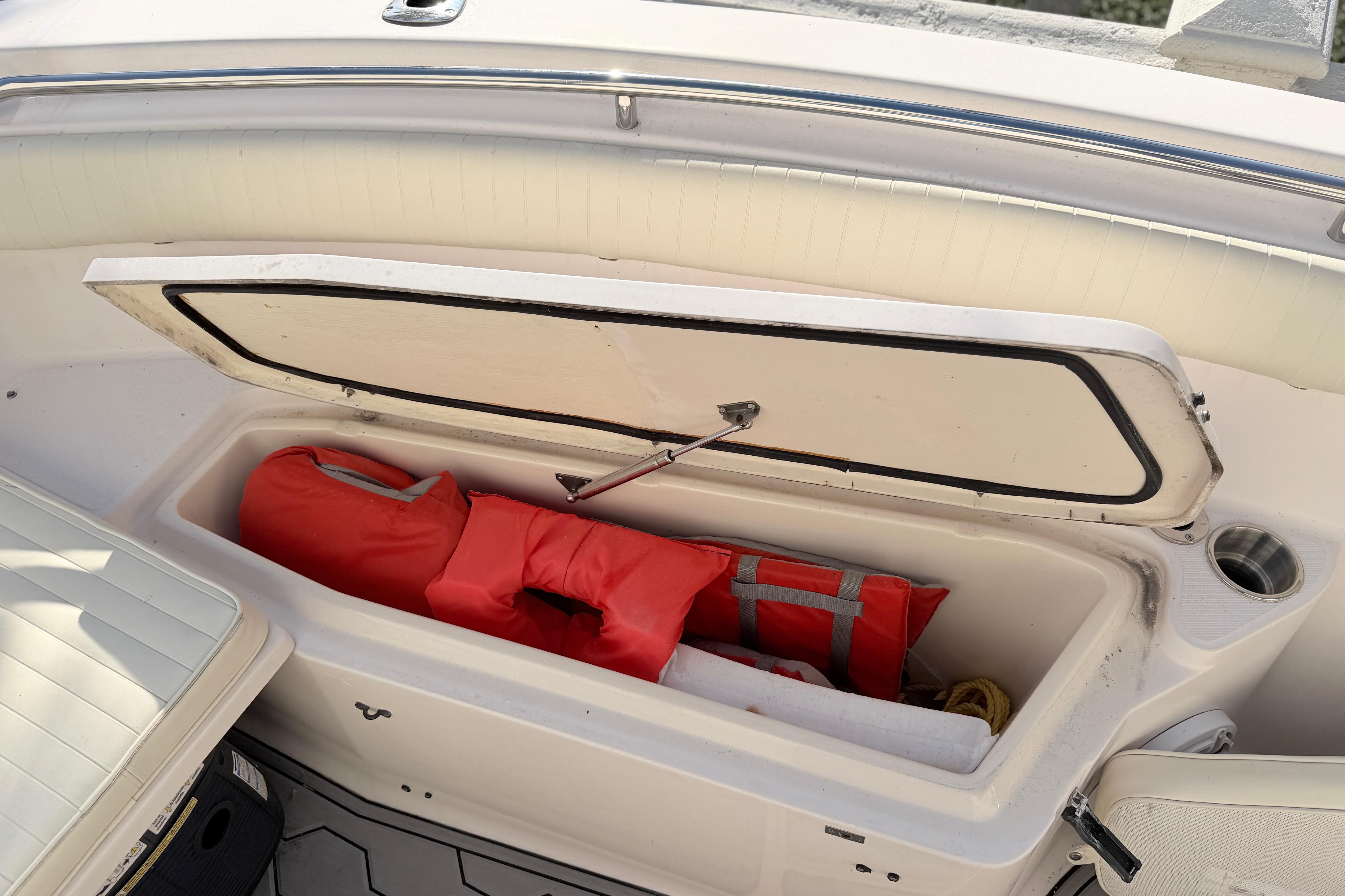 Open storage compartment on 2004 Grady White 273 boat with life jackets inside.