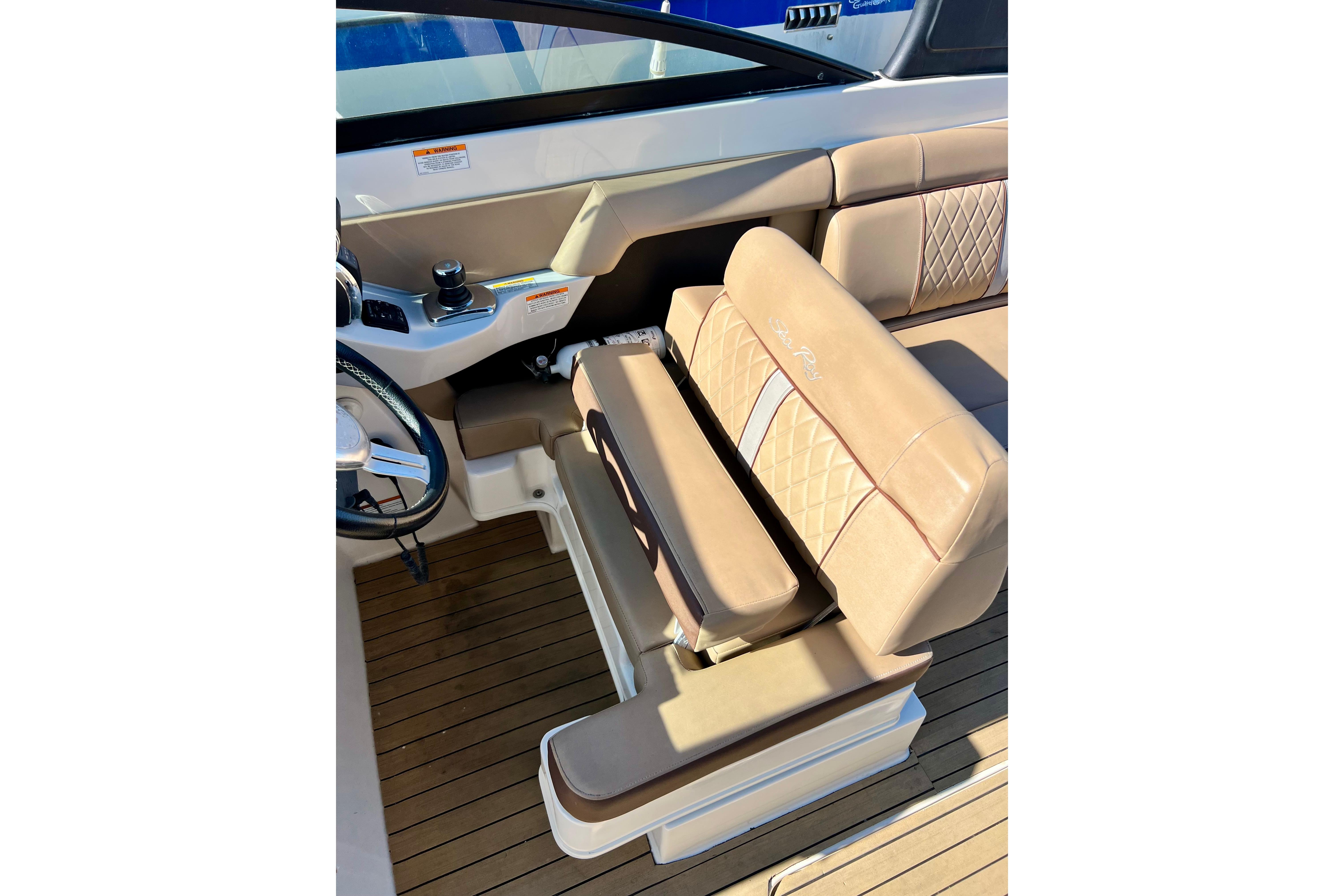 2016 Sea Ray 290 Sundeck Outboard helm with tan leather seating and wood flooring.