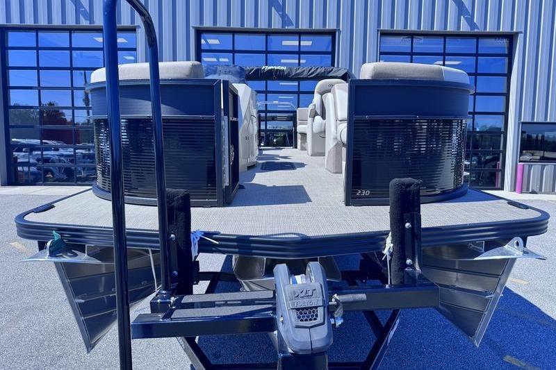 2027 Manitou Aurora 23 RF SHP pontoon boat at a dealership, showcasing modern design.