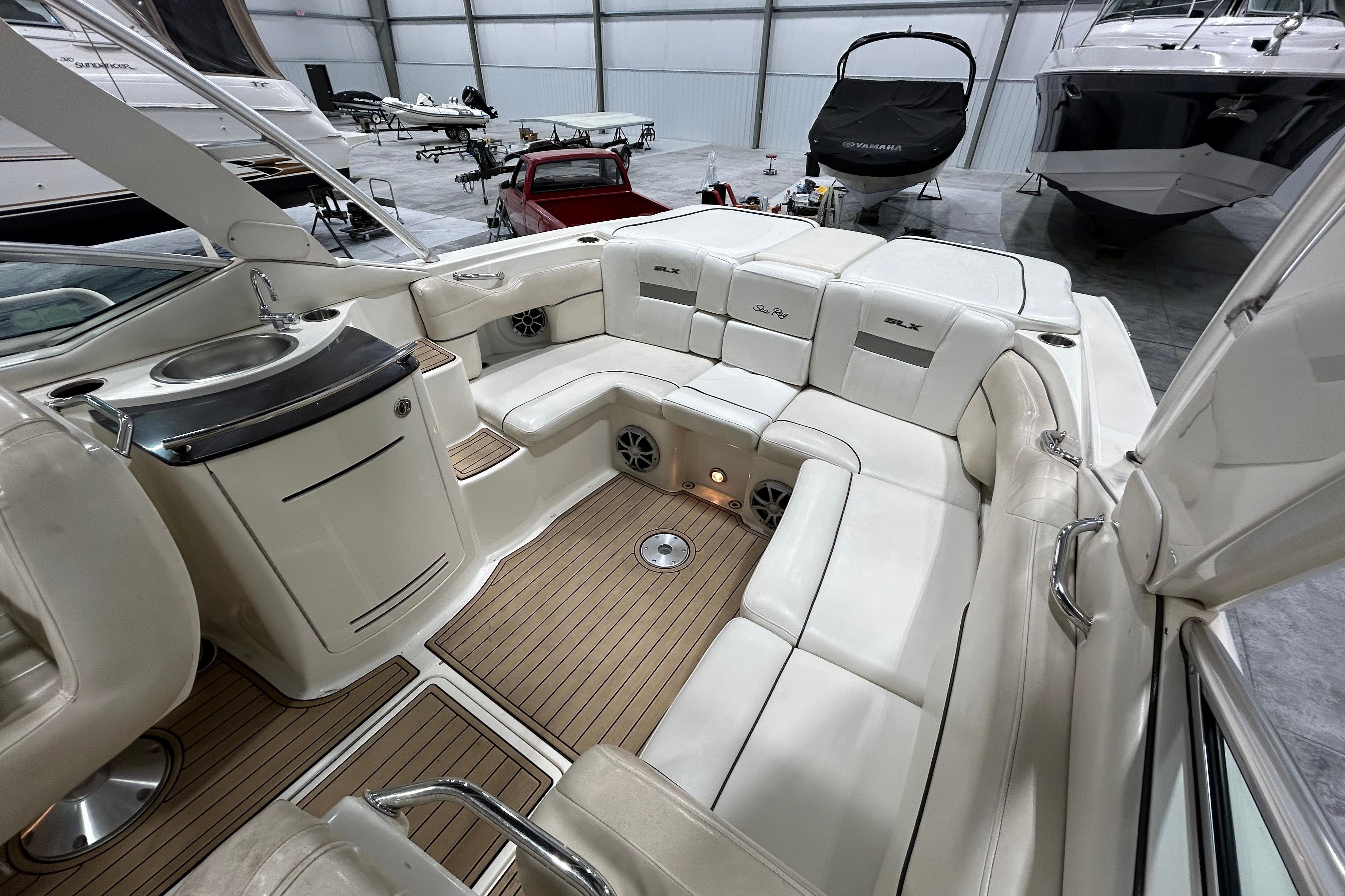 Interior of a 2006 Sea Ray 270 SLX boat with white seating and wood flooring.