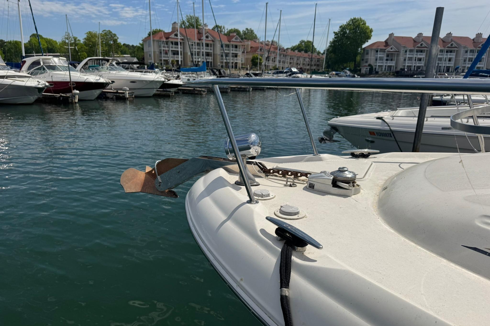 2001 Sea Ray 340 Sundancer docked in a marina with other boats and waterfront buildings.