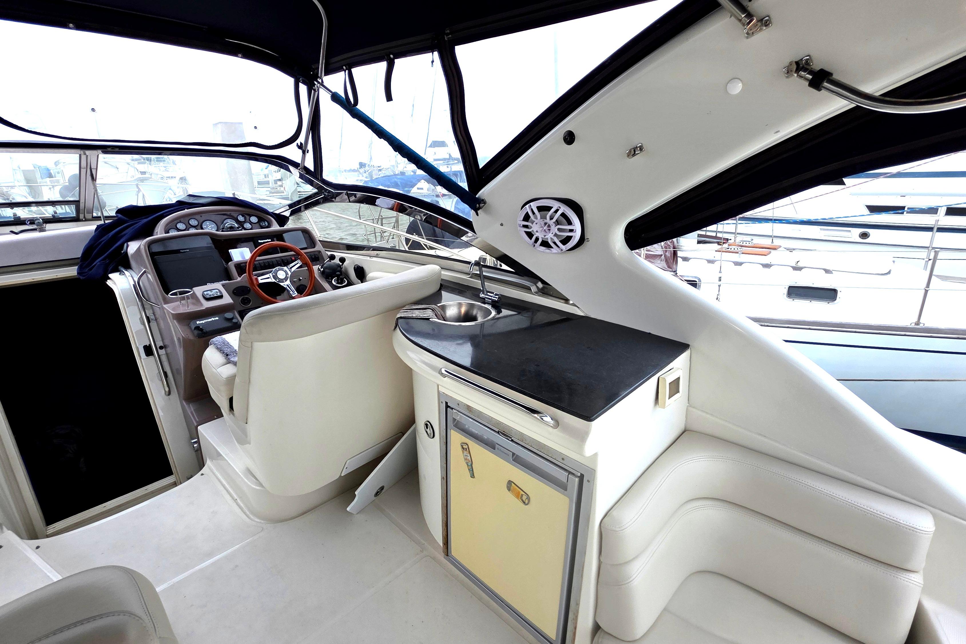 Interior of 2002 Regal Commodore 4260 yacht with helm, seating, and kitchenette.