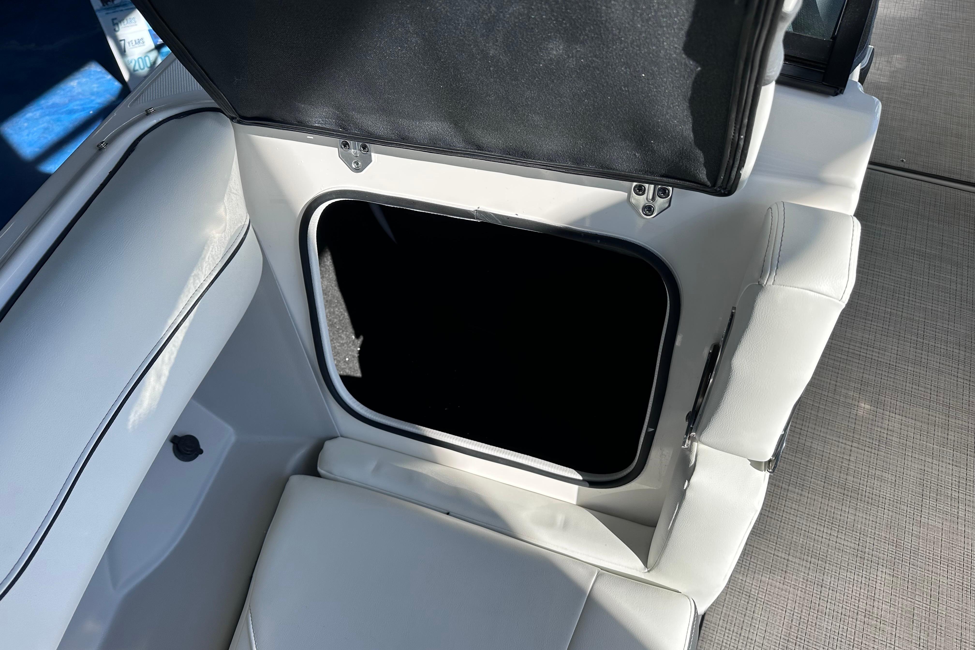Open storage compartment in 2026 Regal LX4 boat with white seating.
