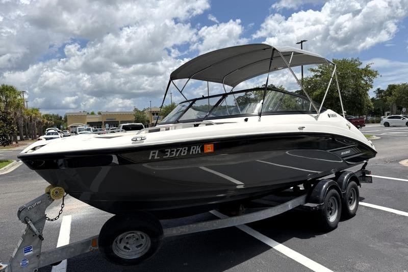 2017 Yamaha Boats SX210 on trailer in parking lot under cloudy sky.