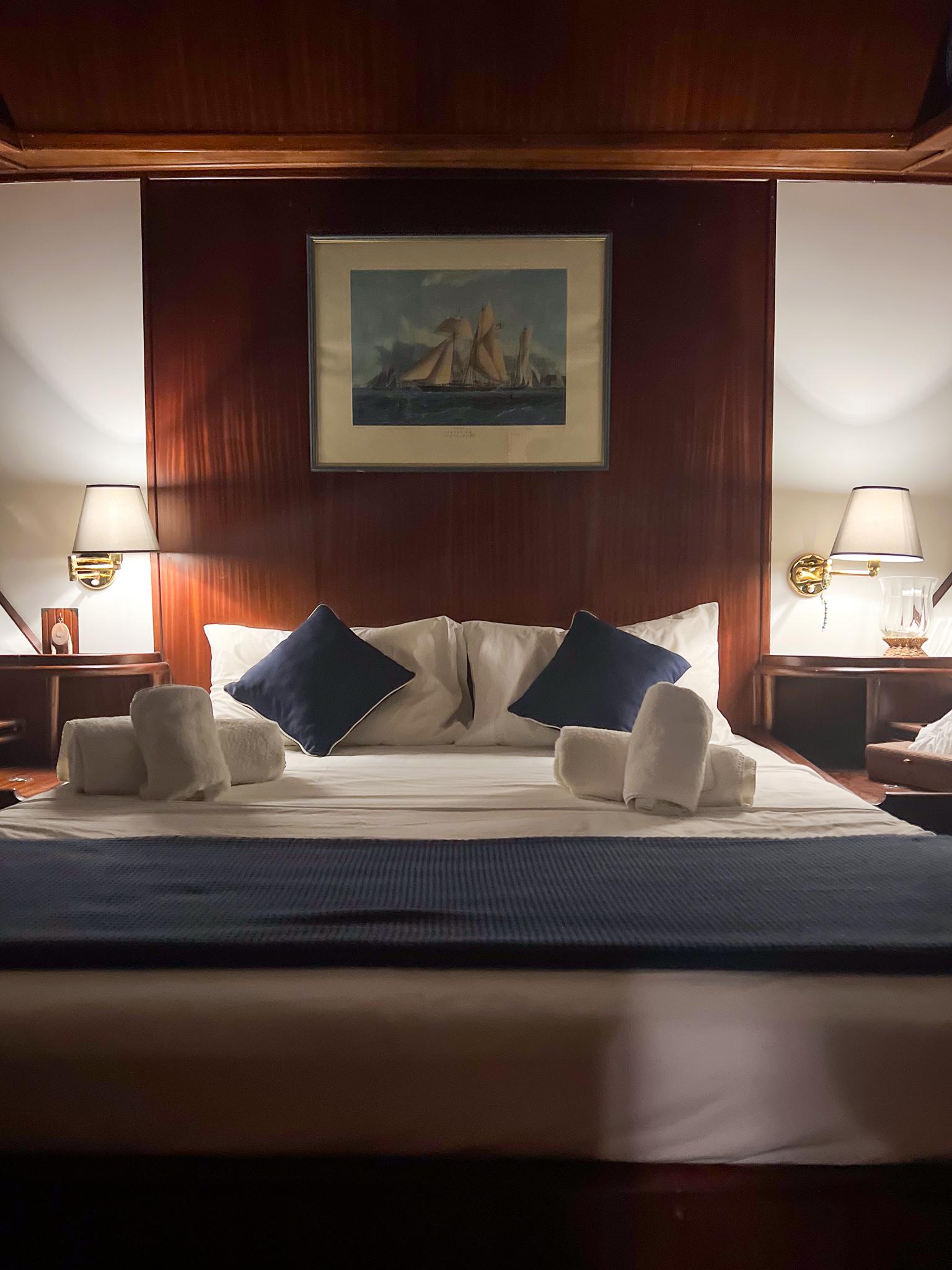 Luxurious cabin interior on a 1969 Psarros Shipyard yacht, featuring elegant bedding and ambient lighting.